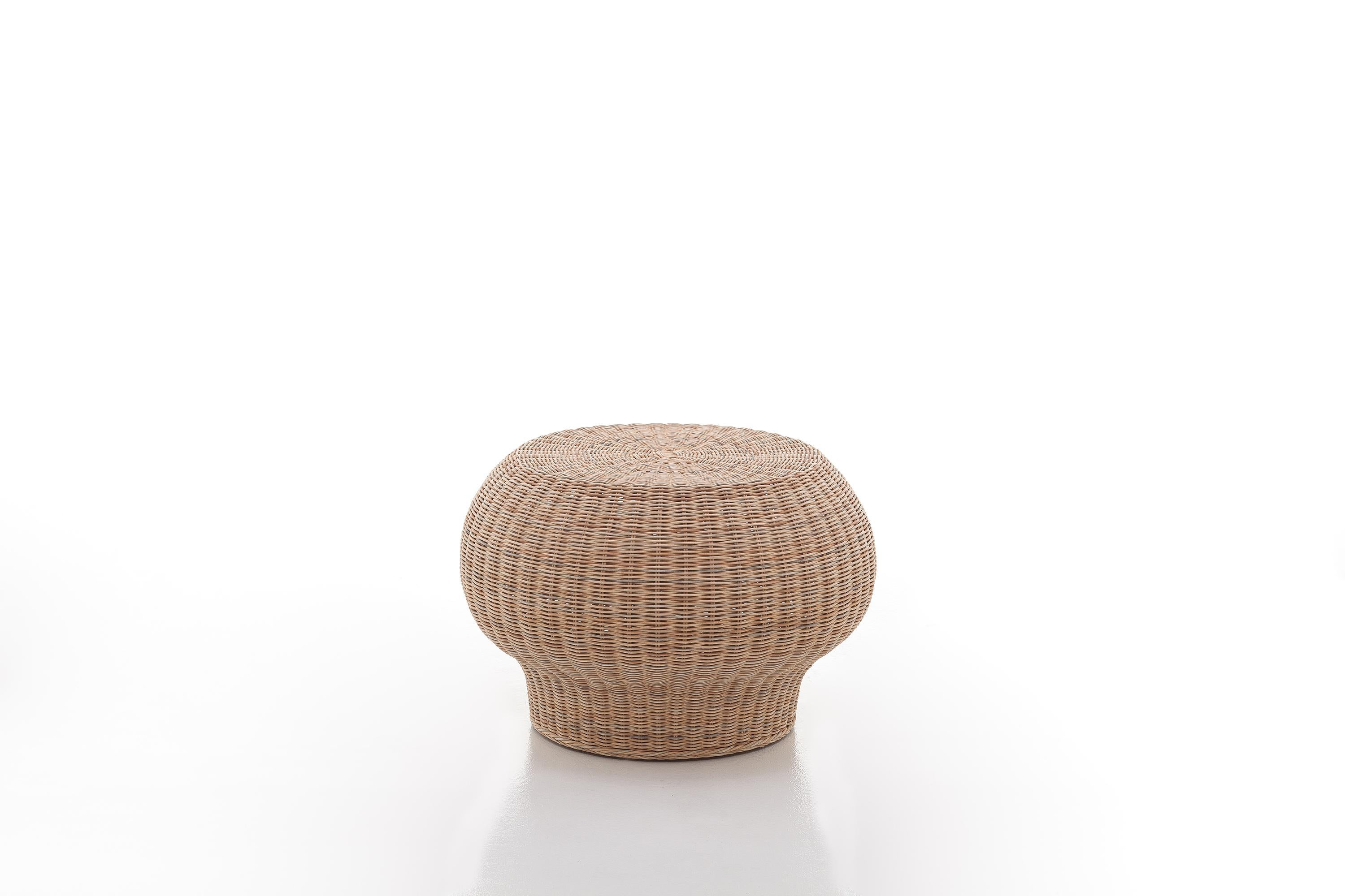 Family of small pouf-tables made entirely of natural mélange woven wicker or lacquered in matt white, grey, black, ocean or dove-grey, characterised by a low and rounded shape with full volumes and a skilful play of workmanship, shapes and colours.
