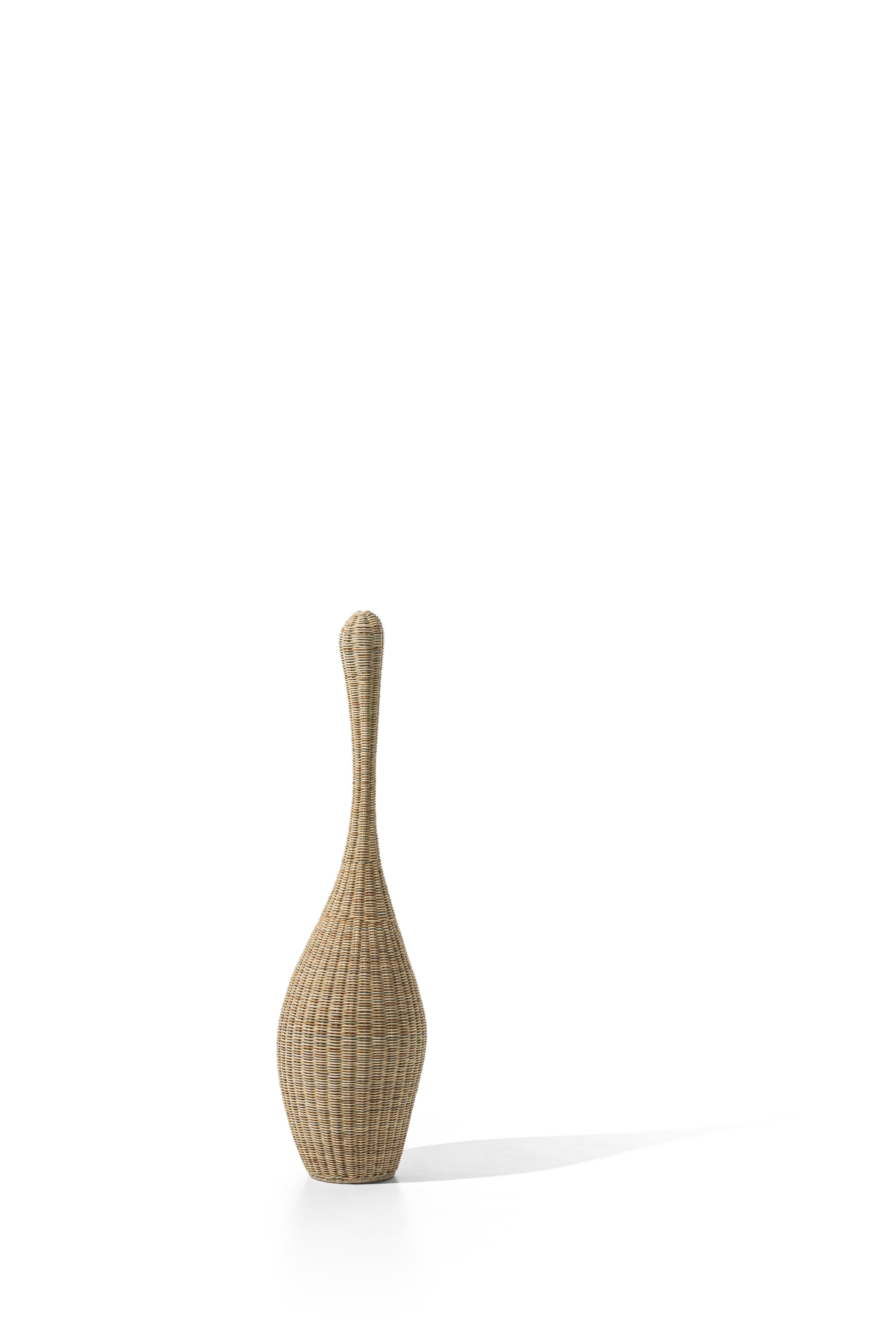 Family of lamps made entirely of natural mélange woven wicker or lacquered in matt white, grey, black, ocean or dove-grey, characterised by a shape that recalls that of a bottle and by a skilful play of workmanship, shapes and colours. The products