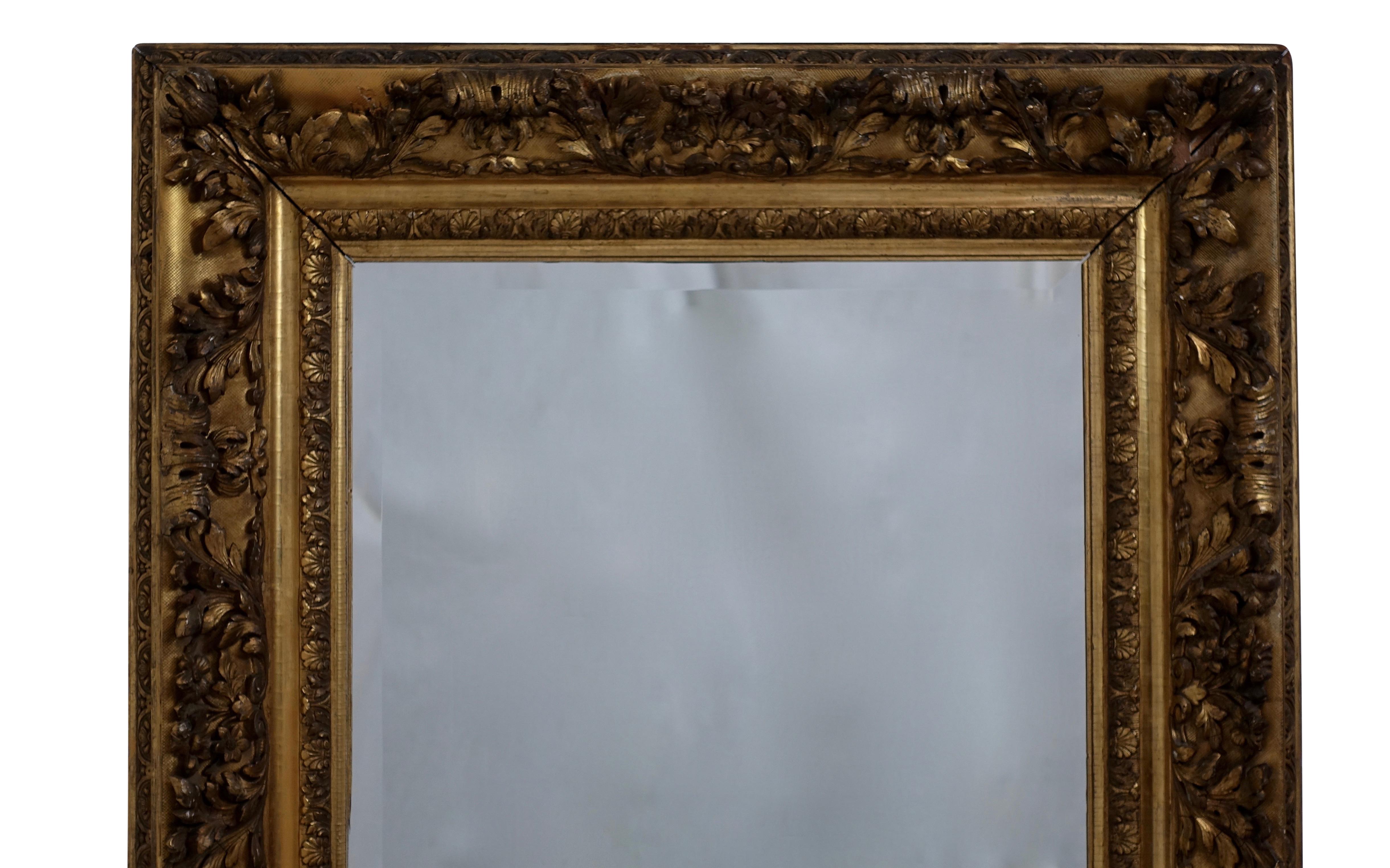 Unique gesso and carved gilt frame of flowers and acanthus leaves with a beveled glass mirror. English, 19th century.
Label on the reverse. Mirror of later date.