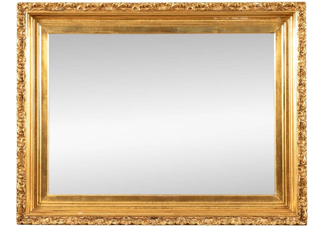 Gesso and gilt rectangular wall mirror with intricate rocaille, foliate and shell gilded motifs. The perimeter of the mirror accentuated with a fine beaded element. The mirror glass with a 3/4