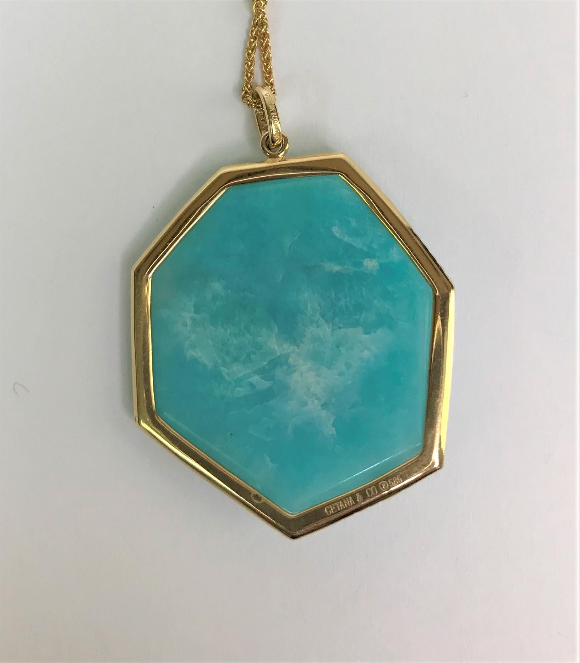 By designer Getana & Co.
14 karat yellow gold
Bluish green freeform amazonite with a halo of diamonds.  Beautiful color!
Bail also has diamonds
Approximately .28 total diamond weight
Overall pendant approximately 32mm x 29mm
Pendant stamped 