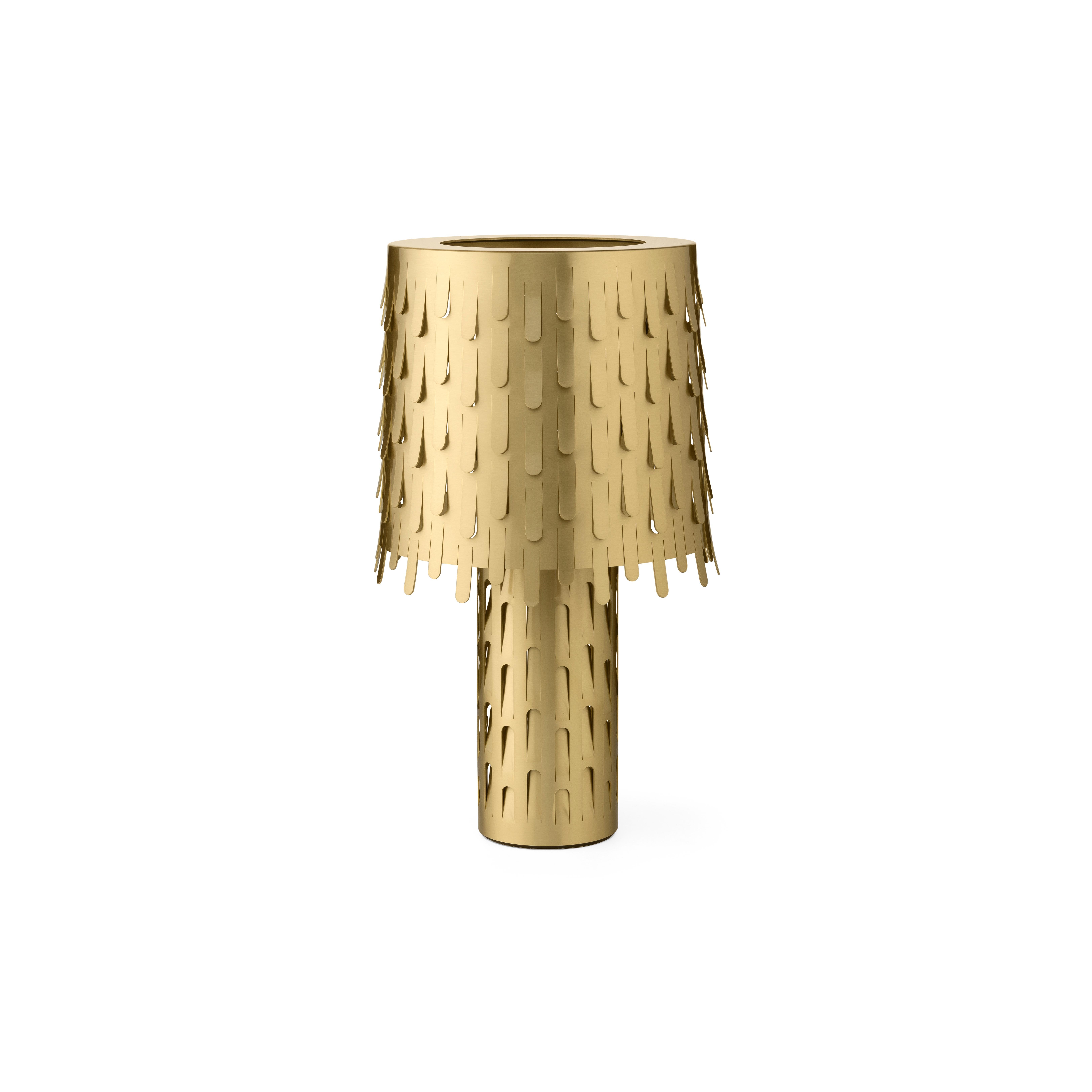 The lamp is made of polished brass, synonymous of elegance and preciousness. It is composed of two overlapping cylinders, the large stem supports an important lampshade decorated with a thousand leaves bent by the wind. The perforated structure and