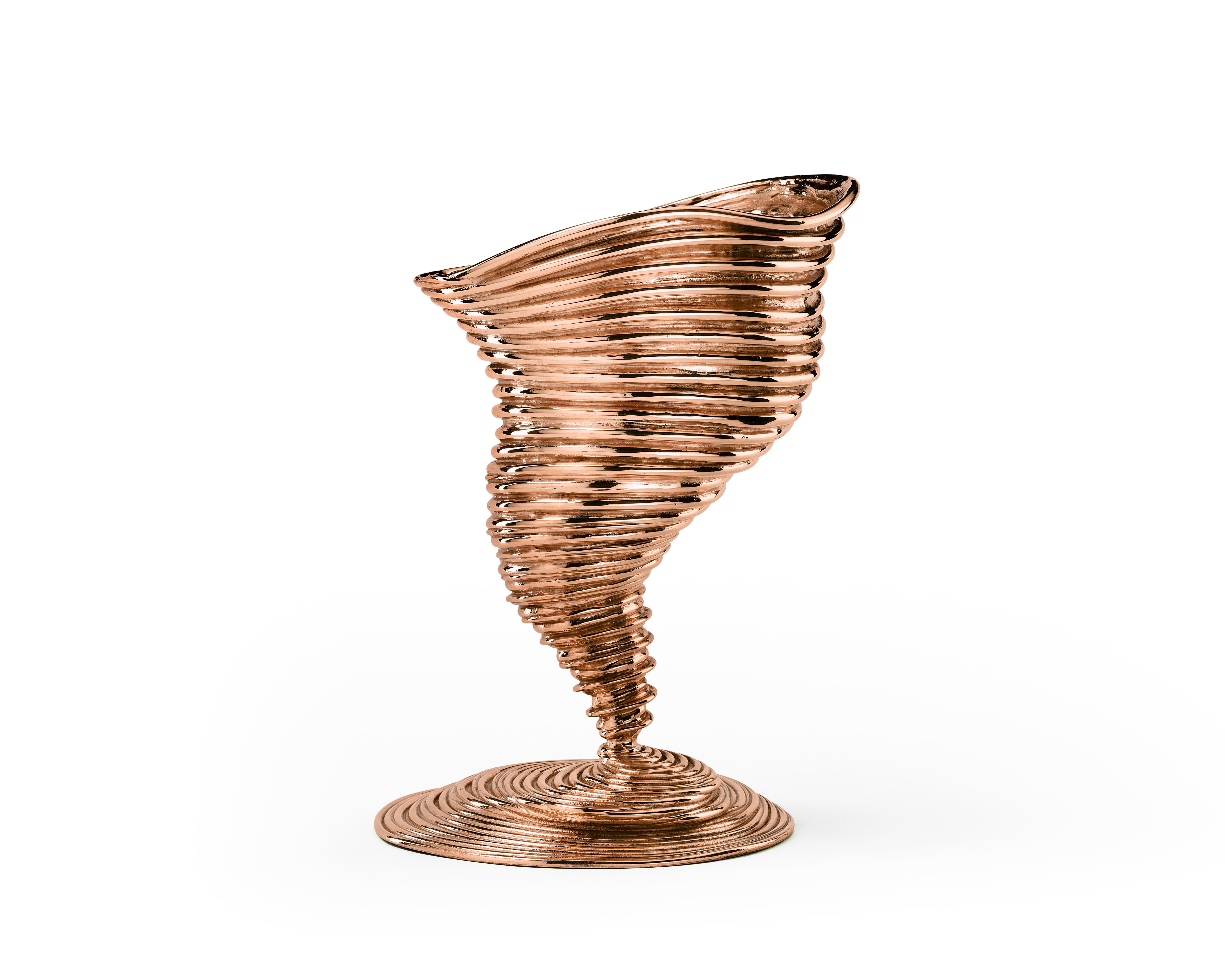 Espiral de latón, vórtice vertiginoso de luz reflejada. Mil anillos líquidos surgen de un hipotético mar, se expanden y se coronan de fragantes flores. Es un objeto muy evocador, fascinante por su forma y su brillo. El diseñado por los Campana