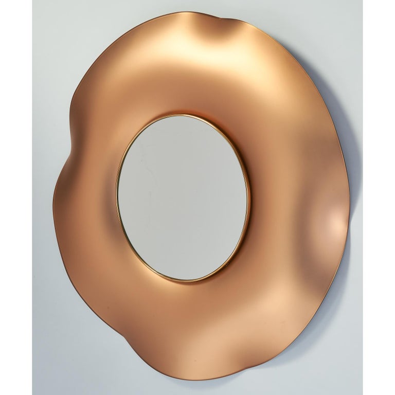 Ghiro Studio, 2018
A mirror of undulating richly colored glass in a pink gold hue, with satin finish, inner polished brass frame.
Dimensions: 32.5 diameter x 3 depth
Signed on back.

 