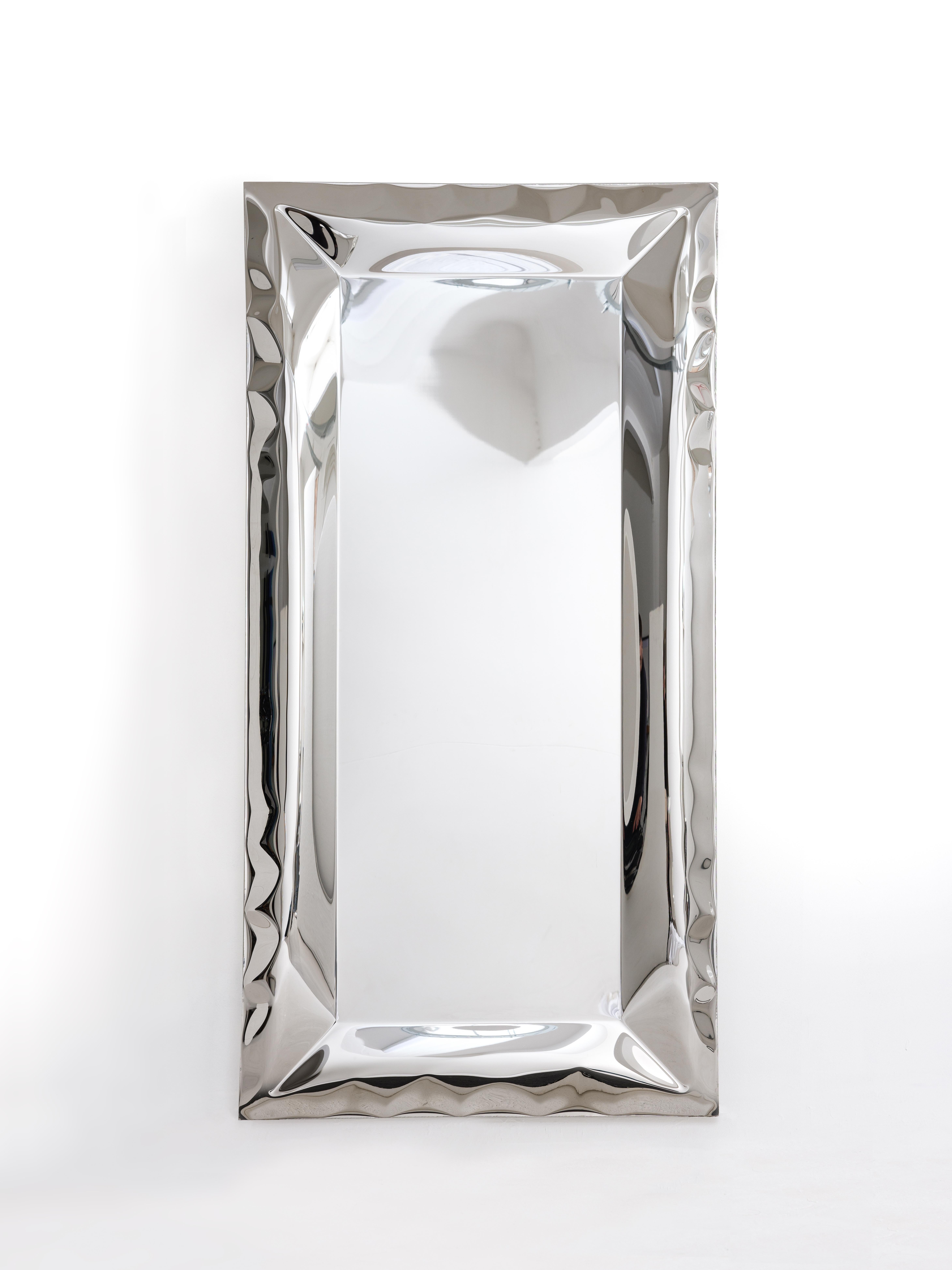 Inflated metal wall mirror, made from an uninterrupted sheet of highly mirror polished stainless steel. The flat central area forms a clear reflective mirror when up close, as you move further away from the mirror the reflections change and distort