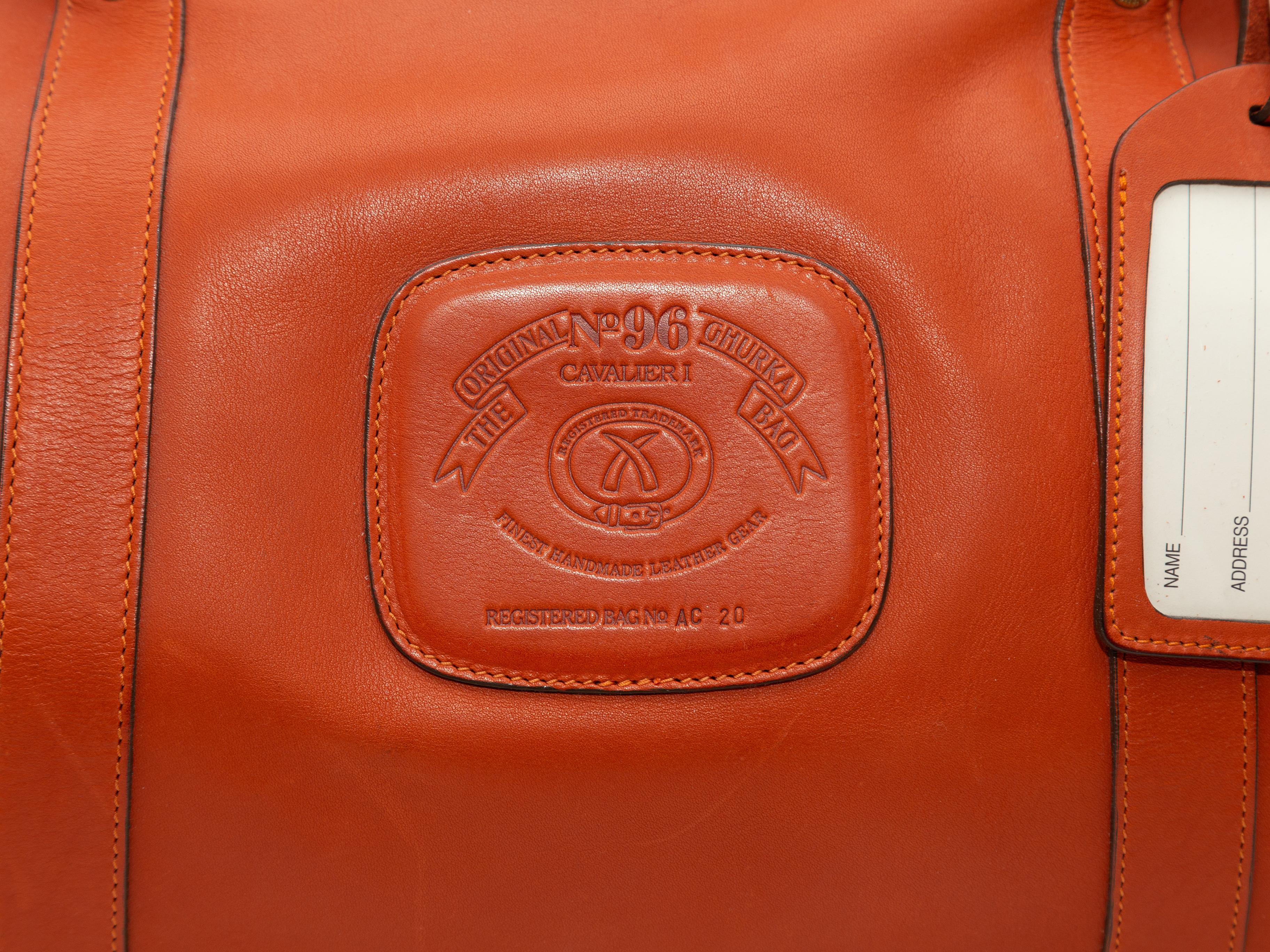 Product details: Orange leather No. 96 Cavalier Duffel Bag by Ghurka. Gold-tone hardware. Dual rolled top handles. Optional shoulder strap. Zip closure at top. 12