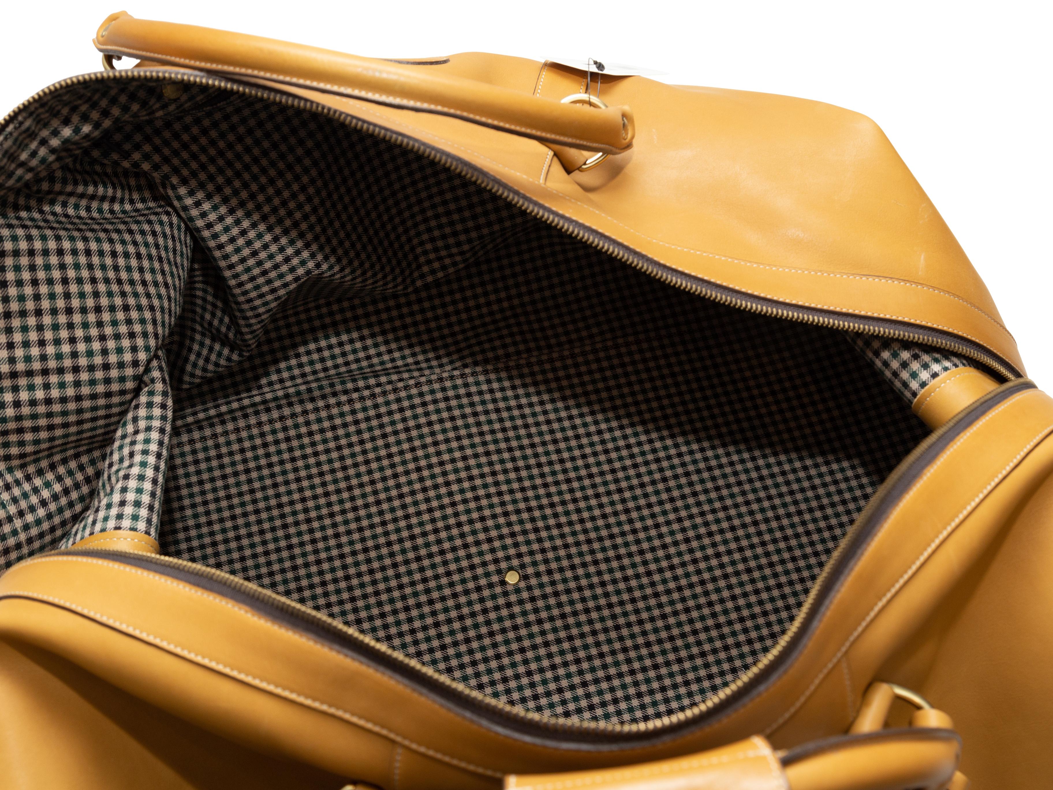 Product details: Wheat leather No. 98 Cavalier Duffel Bag by Ghurka. Gold-tone hardware. Dual rolled top handles. Optional shoulder strap. Zip closure at top. 33