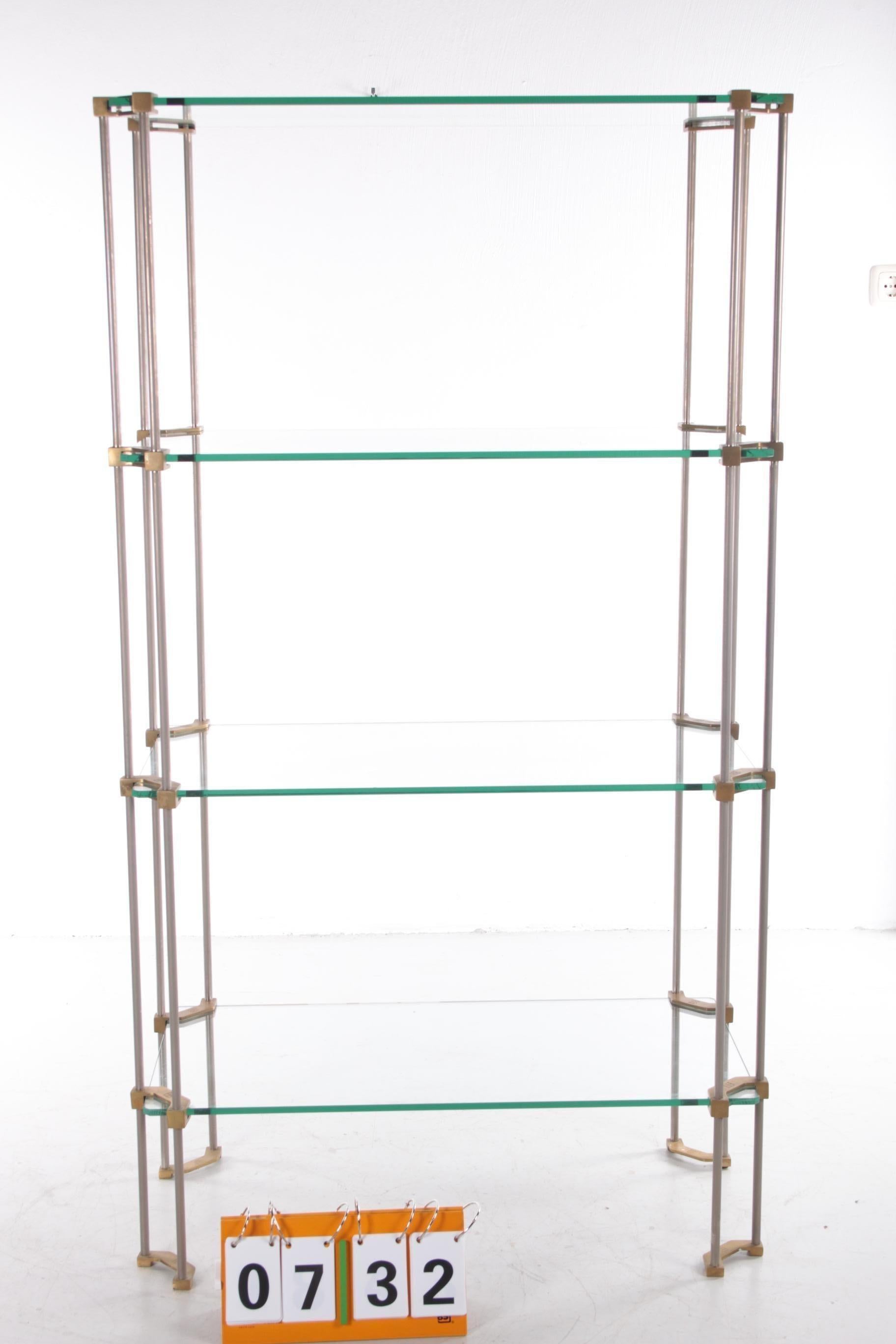 Stylish with allure, that's how you can certainly describe this beautiful vintage bookshelf or wall unit. A design by Peter Chyczy. Period 1960s. The combination between the beautiful thick heavy glass top and the eye-catching brass frame makes this