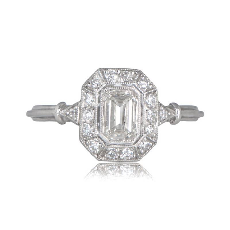 A stunning halo engagement ring, artistically inspired by English designs, highlights a vibrant 0.51-carat emerald cut diamond at its center. The ring's elegance is enhanced by the triple wire shank and delicate milgrain detailing. The center