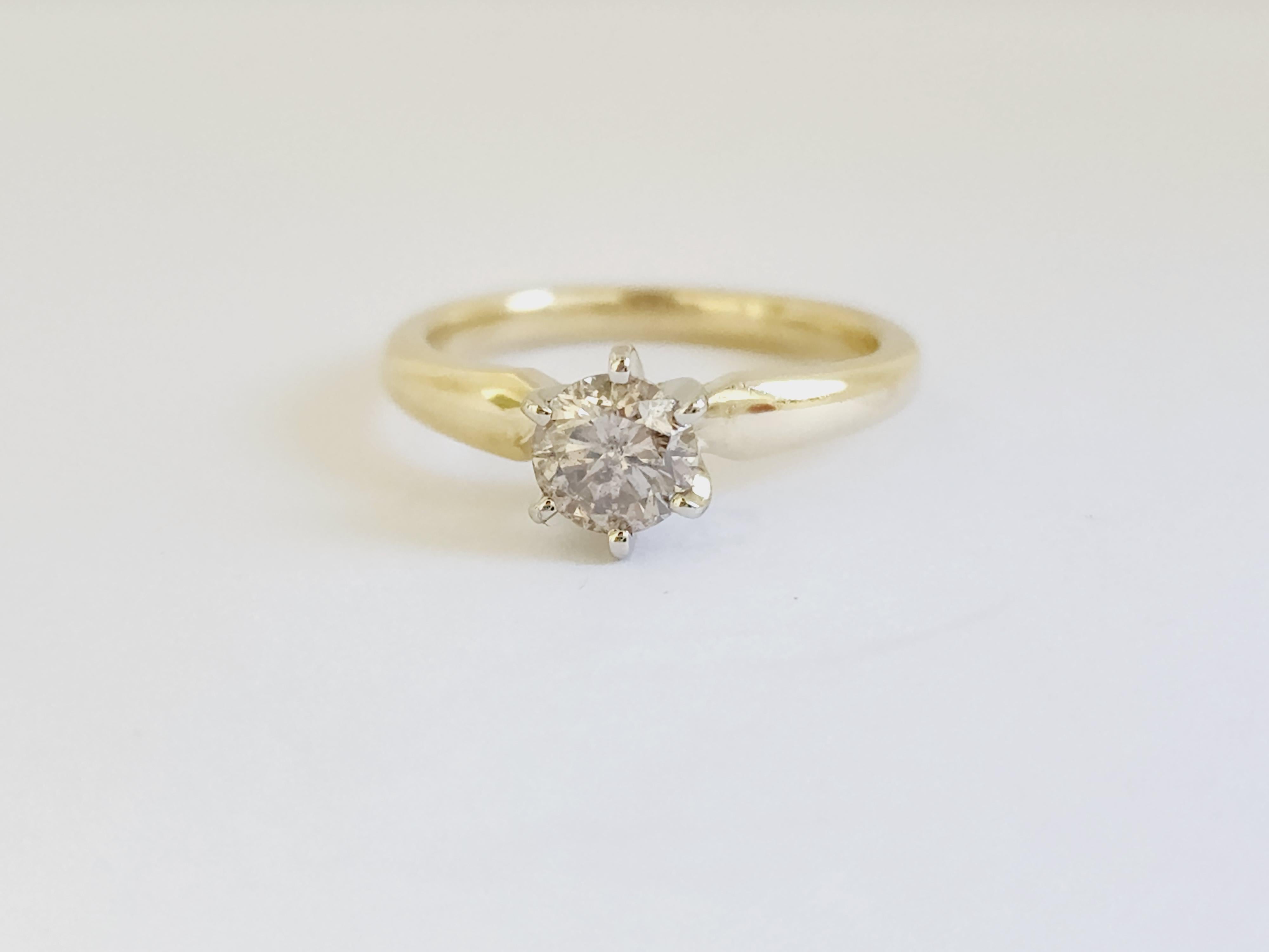 Diamant rond de couleur naturelle brun clair pesant 0,76 carats. 
Monté sur or jaune 14K à 6 branches.
Taille de l'anneau : 6.5