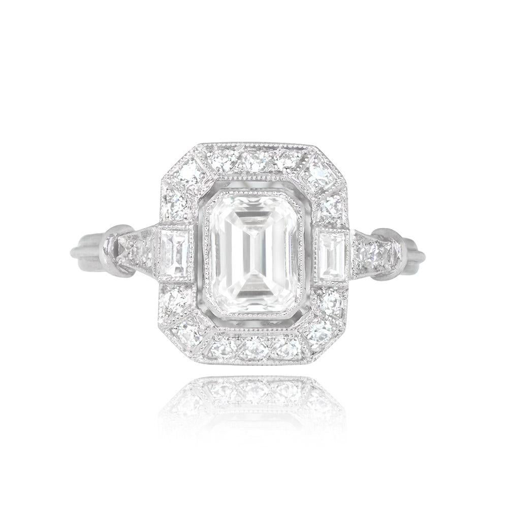 This elegant engagement ring features a GIA-certified 0.80-carat emerald cut diamond with I color and VS1 clarity at its center. The central diamond is encased in a bezel setting and complemented by two sparkling baguette-cut diamonds. Round