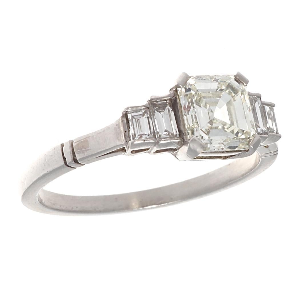 This ring speaks for itself, in all its stunning simplicity. GIA certified 1.01 carat Asscher cut, K color, VS1 clarity, is beautifully set in platinum.
In classic Art Deco style, the accenting emerald cuts are tapered and snugly set next to the