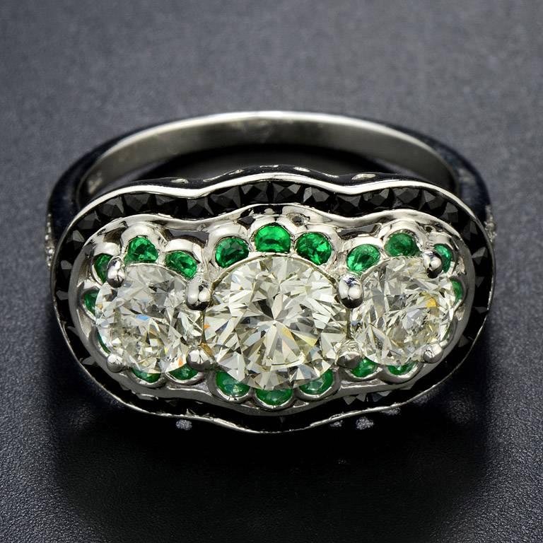 GIA Certified 1.01 Carat Round Brilliant cut Diamond L Color VS1 Clarity in the Center and 2 of Round Diamonds 1.10 Carat weight. Surrounded by Emerald 20 pieces 0.40 Carat and Onyx 36 pieces 0.62 Carat.

This Ring was made in 18k White Gold Size