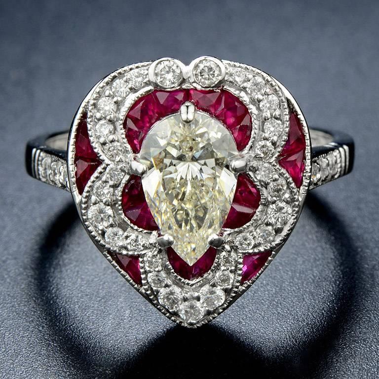 GIA Certified 1.01 Carat Diamond I Color VS1 Clarity Pear Shape Brilliant Cut in the center with French Cut Ruby 18 pieces 1.1 Carat and Diamond 35 pieces 0.28 Carat.

This Ring was made in 18k White Gold Size US#7