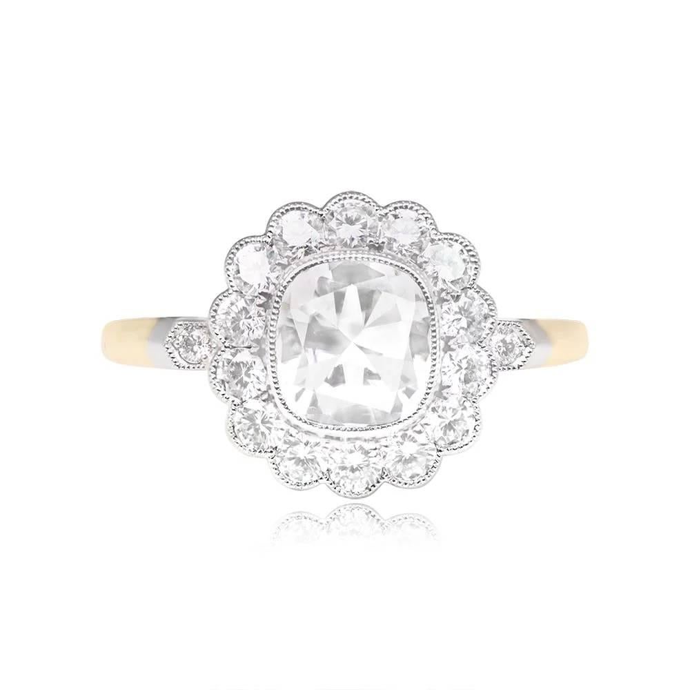 This engagement ring boasts a certified 1.01-carat vintage cushion-cut diamond, GIA-graded as E color and SI2 clarity. The center diamond is elegantly bezel-set and surrounded by a captivating floral halo of round brilliant cut diamonds. Each