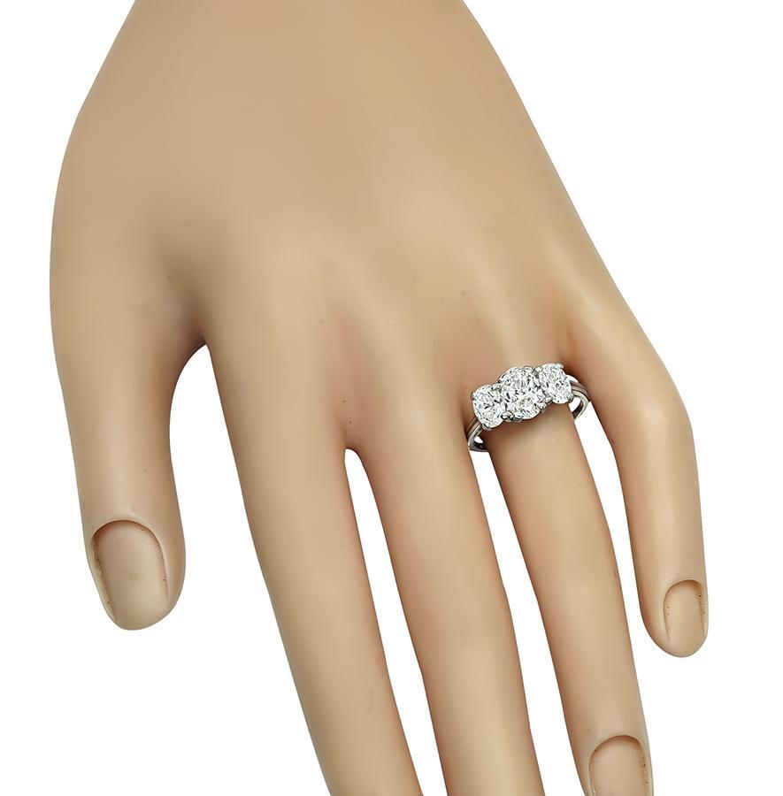 Questo è uno splendido anello di anniversario in platino. L'anello è centrato da uno scintillante diamante taglio ovale certificato GIA del peso di 1,02 ct. Il colore del diamante è H con purezza VS2. Il diamante centrale è accentuato da due