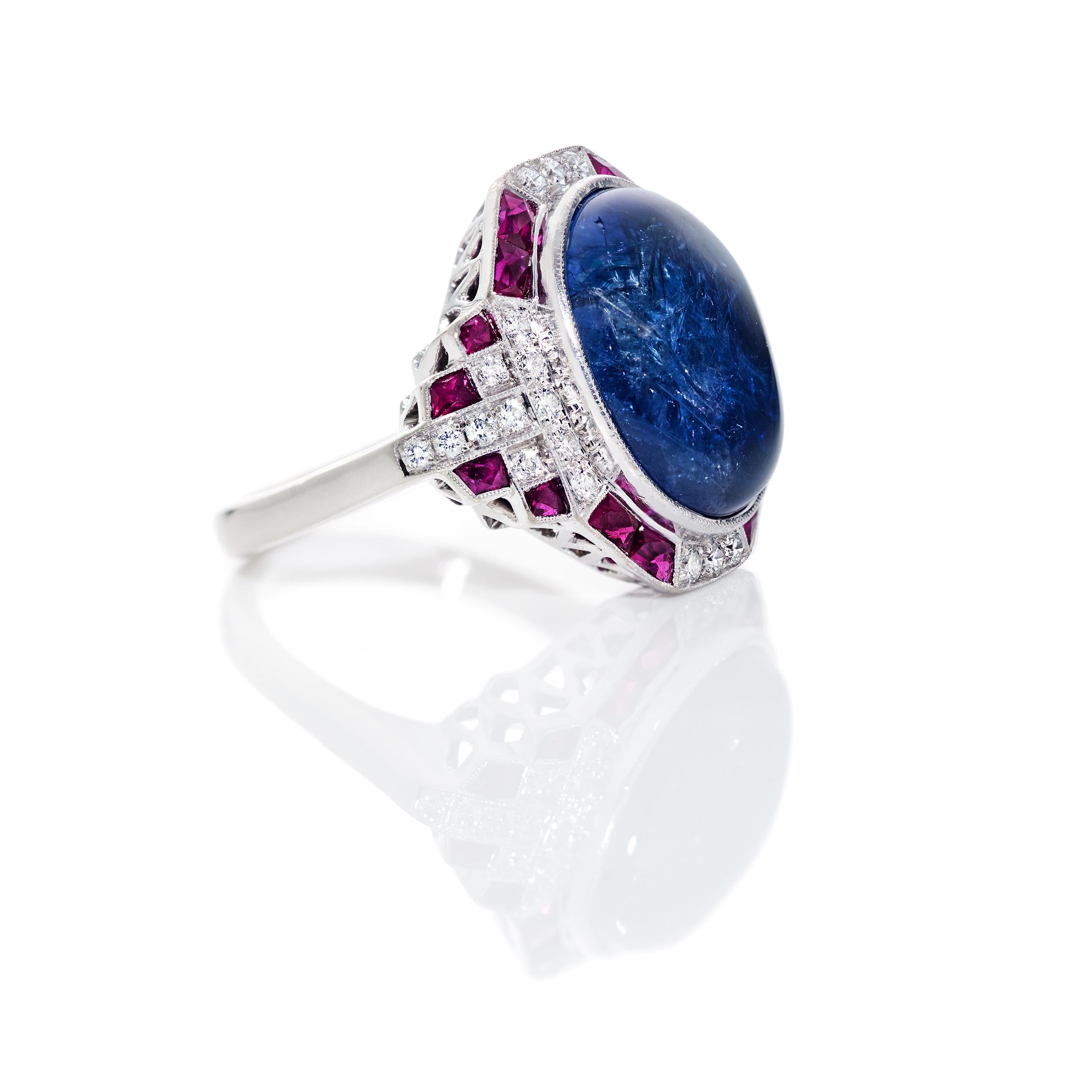 An unbelievable 10.37 Carat Natural, No Heat, Blue Sapphire Cabochon surrounded by 0.80 Carats of Square Cut Rubies and another 0.31 Carats of G/H Color, SI Clarity Diamonds.  This ring is as comfortable as it is striking with its low profile and