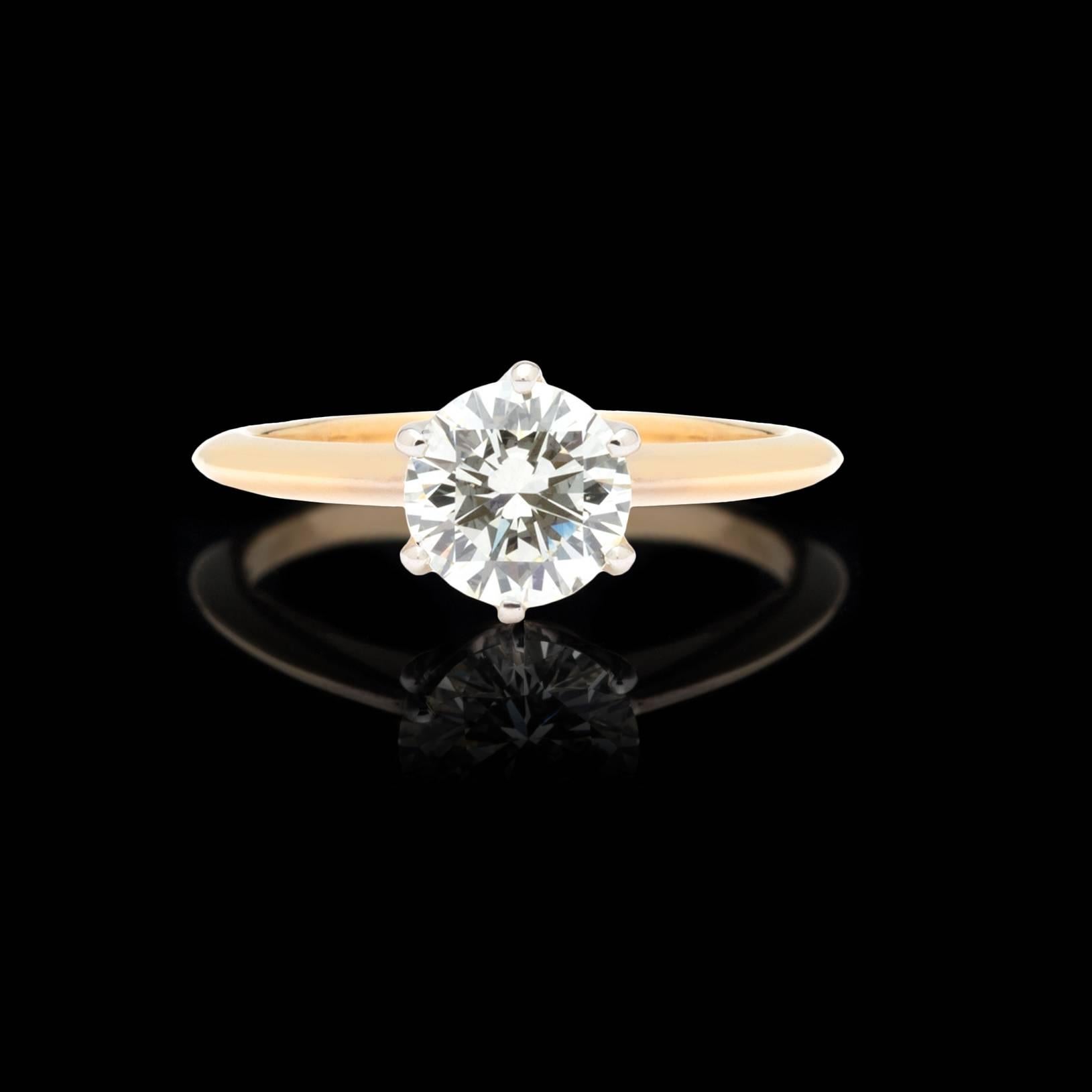 Classic solitaire diamond ring features a 1.04ct round brilliant diamond on a Tiffany style 18k gold band. The diamond was graded K color, VS2 clarity and very good cut by the Gemological Institute of America. Report number 1192086339 is included.