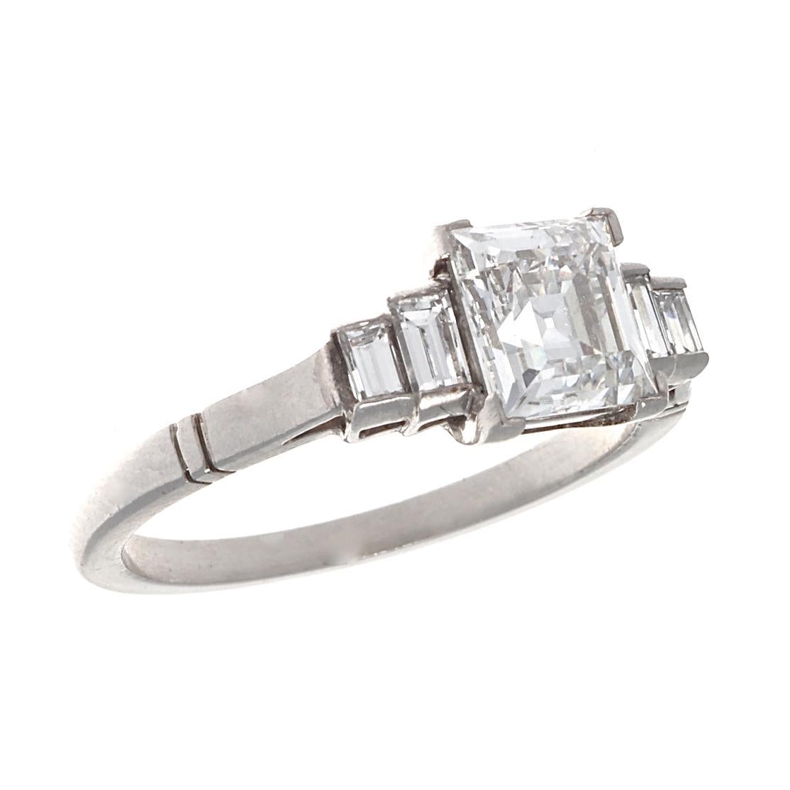 When you want a beautiful emerald cut diamond that reminds you of lightness and joy, you choose the setting that is in accord with such ideals. Featuring a GIA 1.17 carat Carre cut diamond, E color, VVS2 clarity, classic Art Deco lines, and