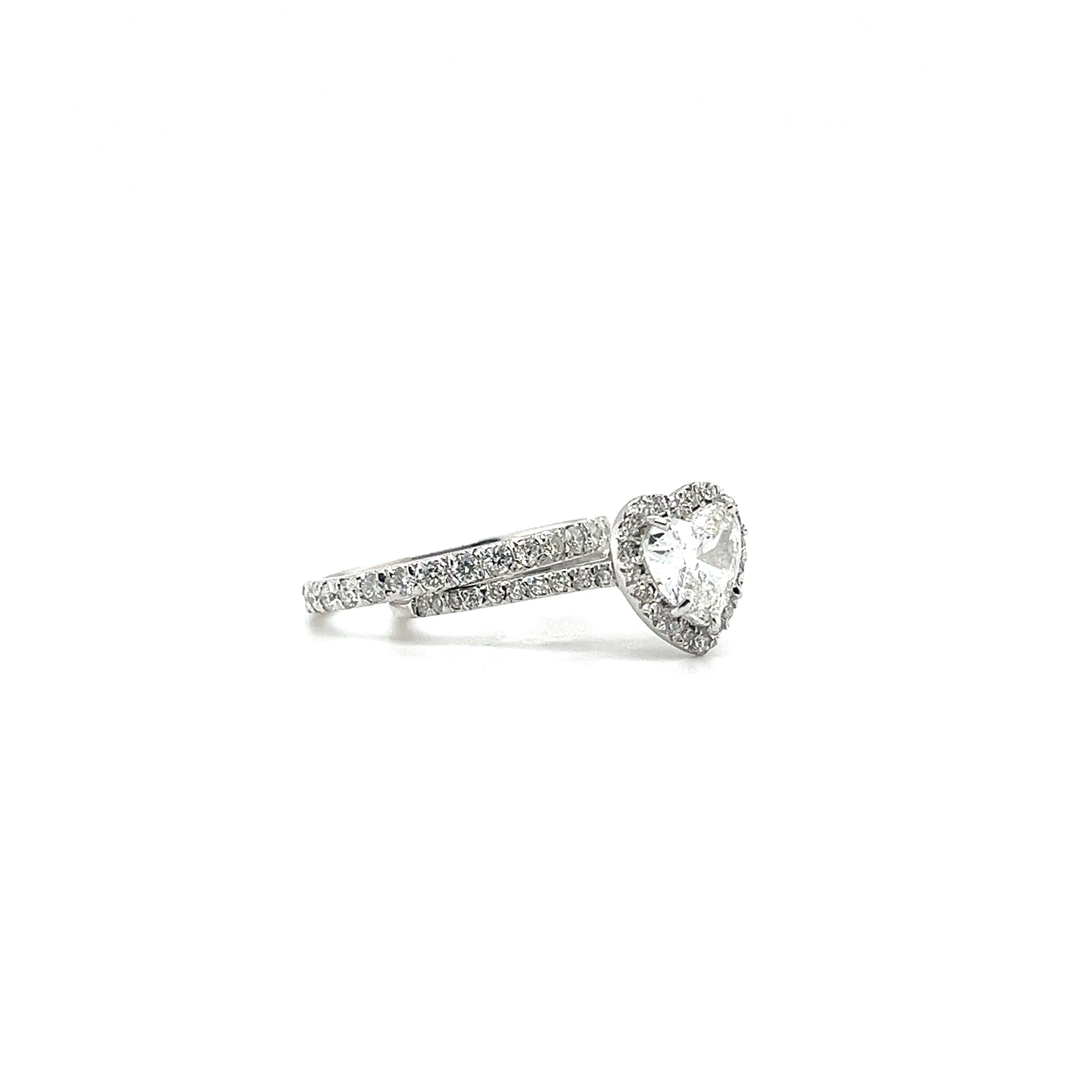 Magnifique bague en diamant en forme de cœur réalisée en or blanc 18kt. Cette bague présente en son centre un diamant en forme de cœur certifié GIA F SI2, entouré de diamants de taille ronde, symbolisant l'amour et la dévotion éternels. Son design