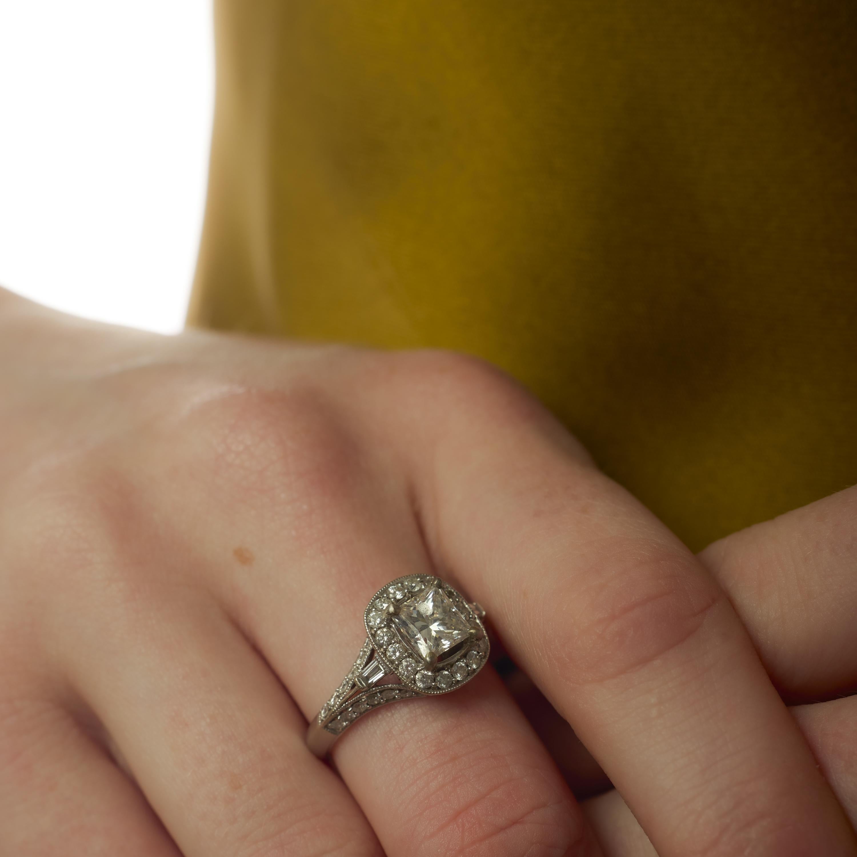 Cette bague vintage des années 2000 est ornée d'un diamant de taille princesse de 1,20 carat, certifié par le GIA (#1232605769), d'une couleur E exceptionnelle et d'un éclat vif. Autour du centre, quarante diamants ronds de taille brillante