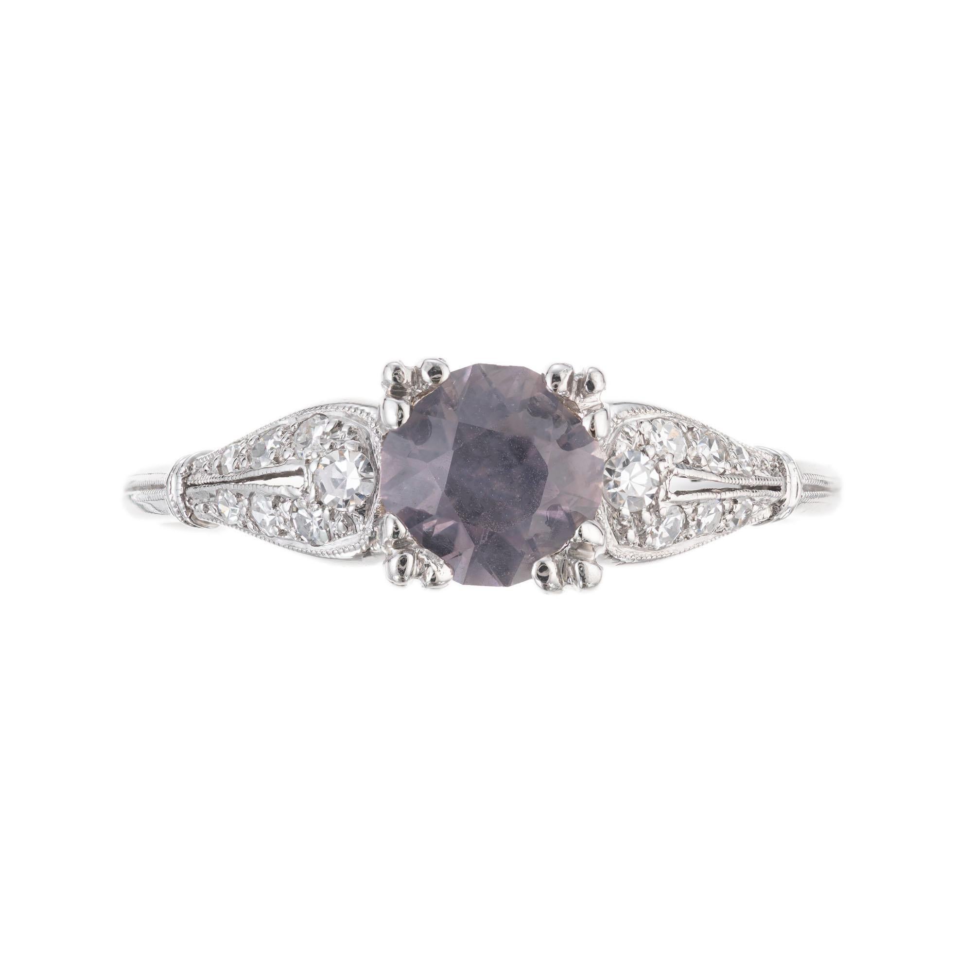 Light purple gray natural sapphire and diamond engagement ring. GIA certified round center sapphire in a handmade platinum setting with 14 round accent diamonds. circa 1940's. GIA certified natural no enhancements.

1 round purple gray sapphire, SI