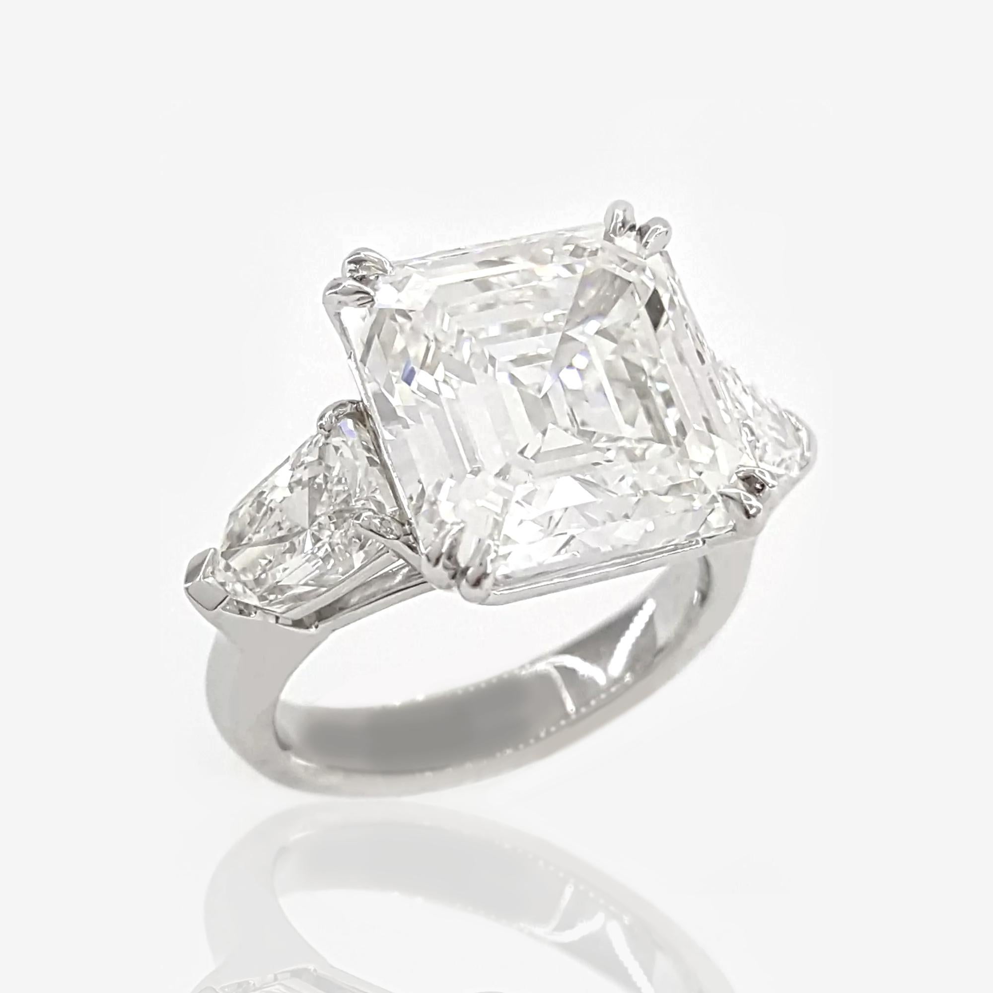 An exquisite platinum ring showcasing exceptional elegance and craftsmanship.

The centerpiece of this stunning ring is a natural Asscher square emerald cut diamond weighing 10.12 carats, graded E in color and internally flawless in clarity. This