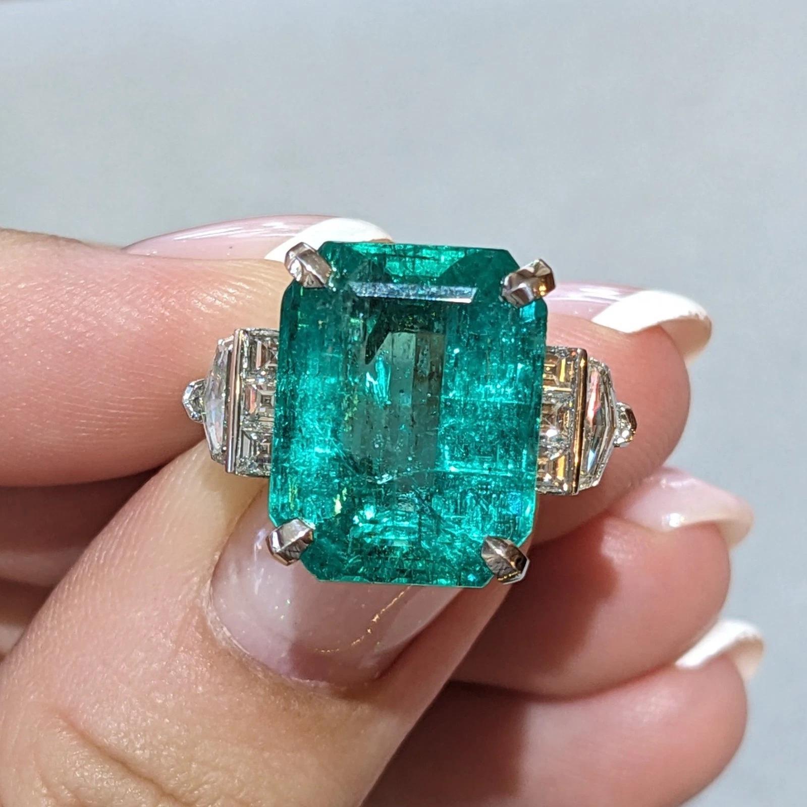 Colombian Emerald and Diamond Ring in Platinum.

Emerald and Diamond Ring features a GIA certified Emerald cut Emerald, weighing 12.49 carats, accented by Square cut and Shield cut Diamonds on the side, all set in Platinum.

Total emerald weight is