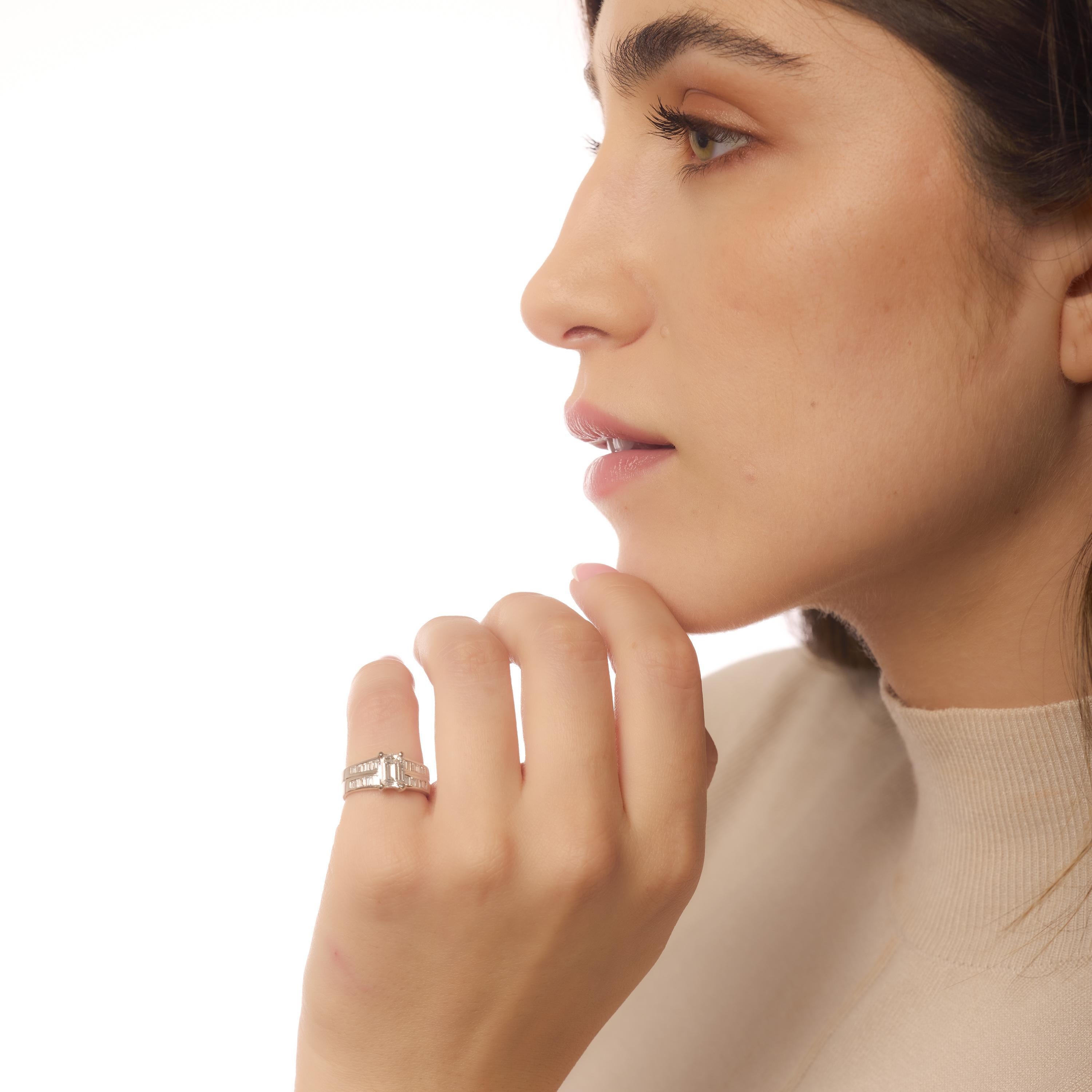 Questo anello in platino sfoggia un diamante taglio smeraldo di colore D da 1,27 carati certificato GIA, accentato da eleganti diamanti a baguette per una silhouette elegante e scultorea.