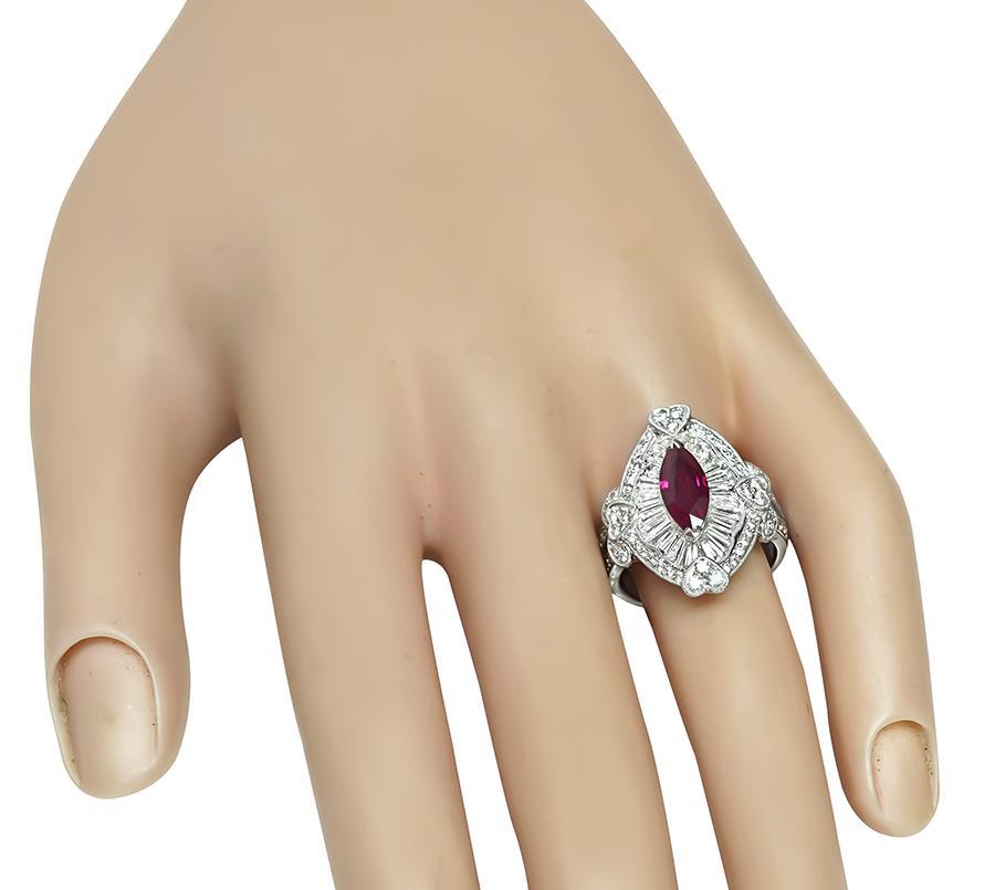 Questo è un elegante anello in platino. L'anello è centrato da un bellissimo rubino di Birmania con taglio a marquise, certificato GIA, del peso di 1,29 carati. Il rubino è accentuato da scintillanti diamanti rotondi e baguette che pesano circa 1,47