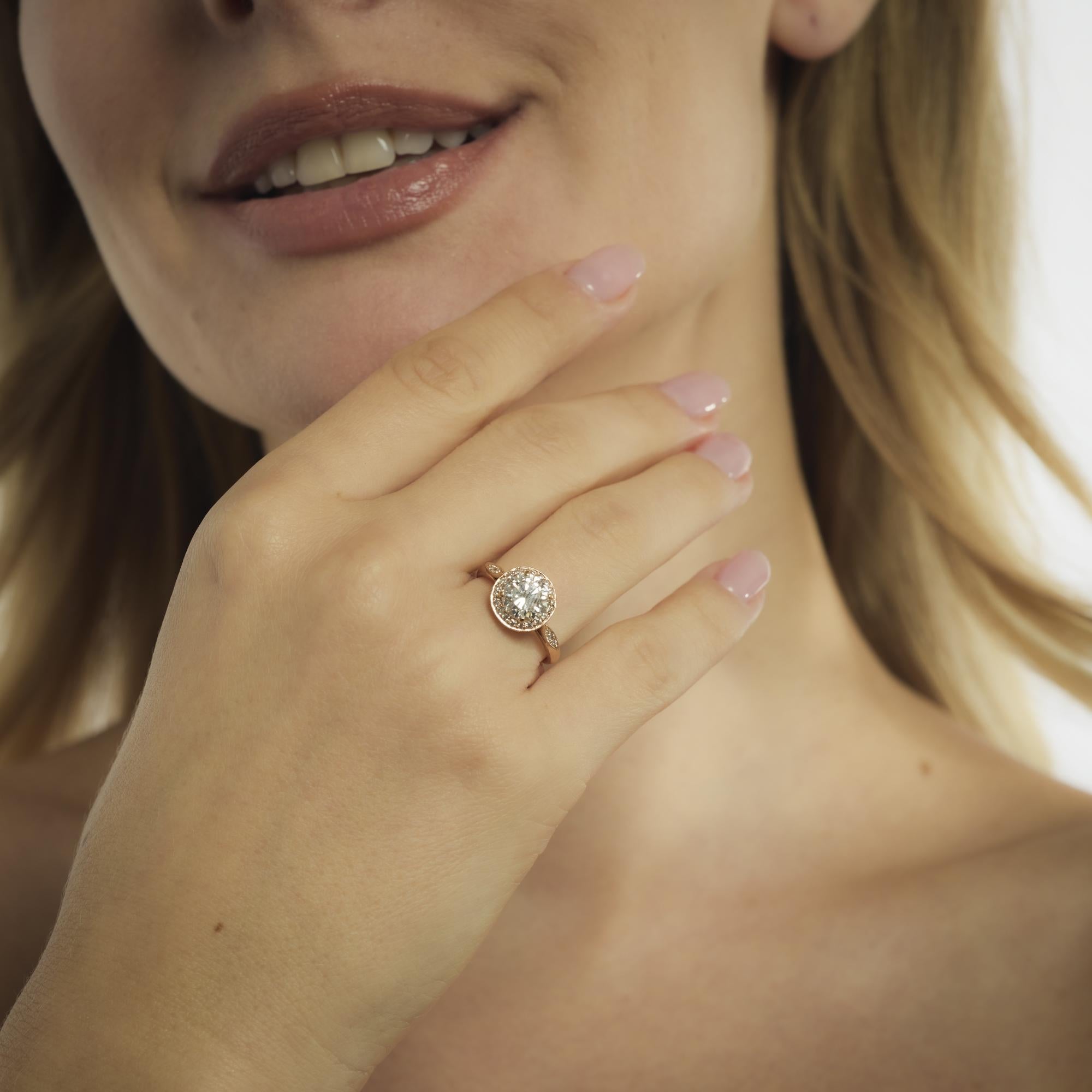 Questo moderno anello in oro rosa 18k degli anni 2020 presenta un diamante rotondo taglio brillante da 1,42 carati con colore H e purezza SI1, certificato da GIA #2233648312. Intorno alla pietra centrale, ventisei diamanti rotondi taglio brillante