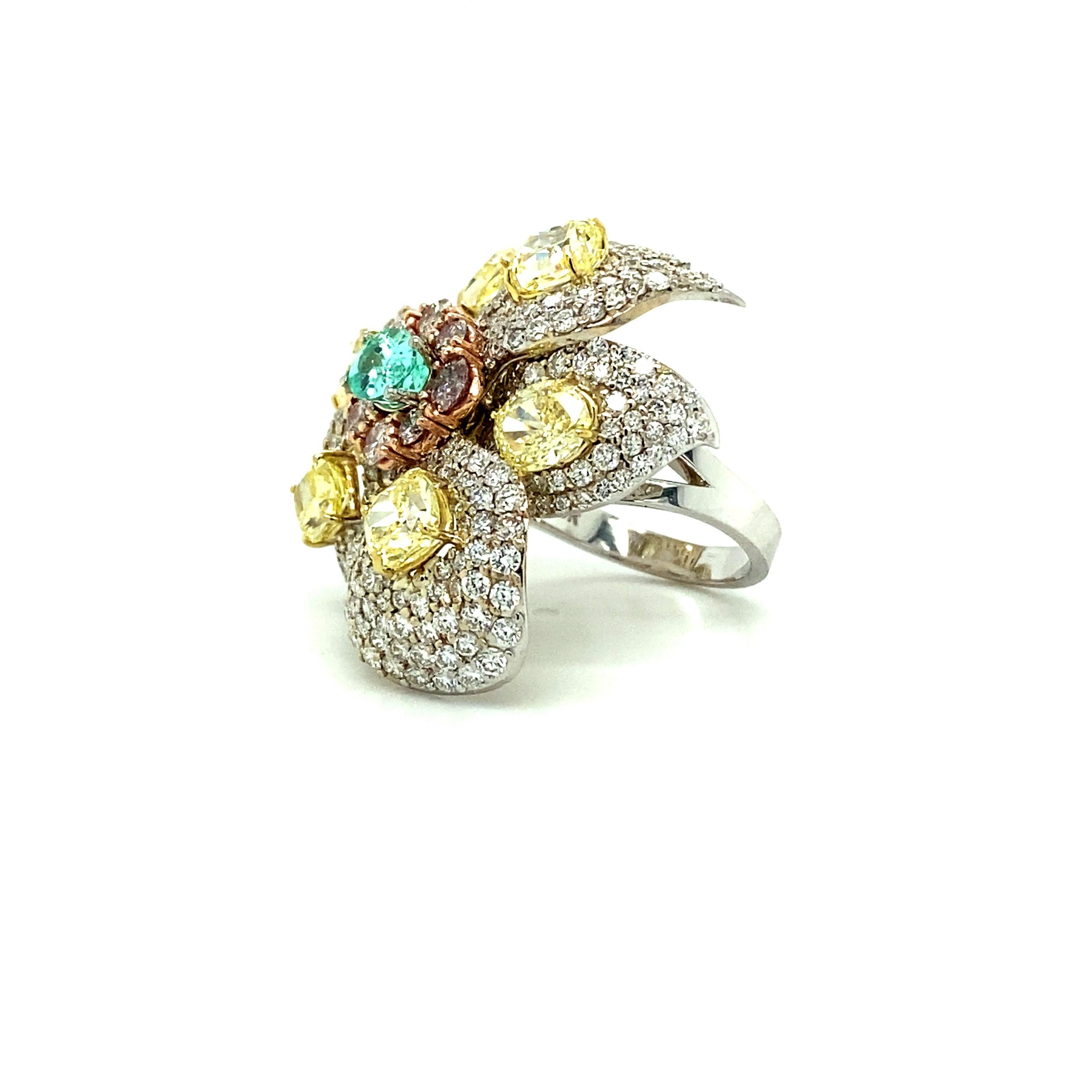 Offered here is a one of a kind flower ring with moving petals. The ring is 18kt White, Yellow & Rose Gold set with 6 fancy to fancy intense yellow natural diamonds & one Paraiba tourmaline oval. 
All 7 stones come with a GIA certificate. 
Diamonds: