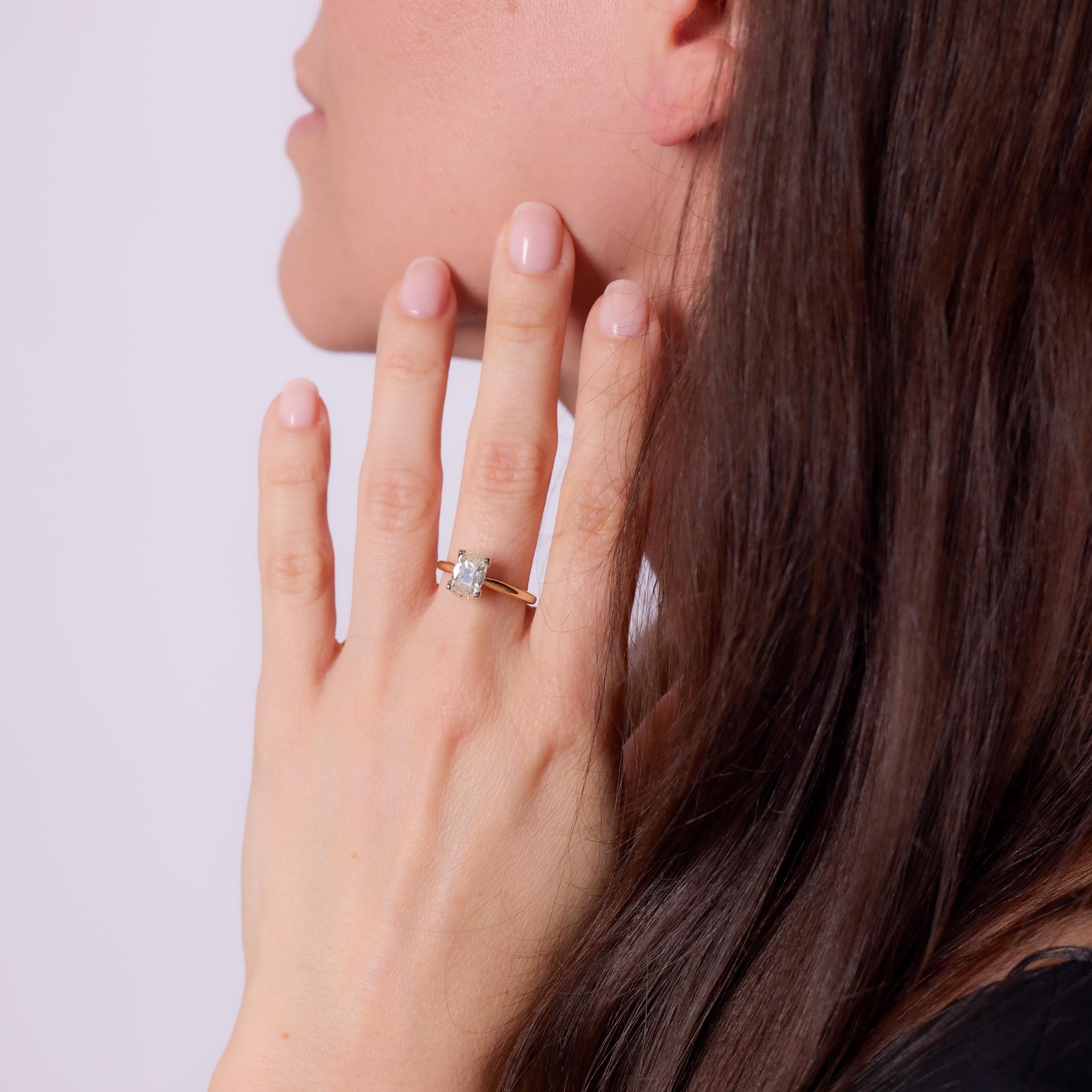 Dieser zeitgenössische Verlobungsring wurde in den 2010er Jahren gefertigt und besteht aus einem GIA-zertifizierten Diamanten im Altminenschliff von 1,50 Karat mit der Farbeinstufung O-P und der Reinheit SI1. Die antike Form und die sanfte Wärme des