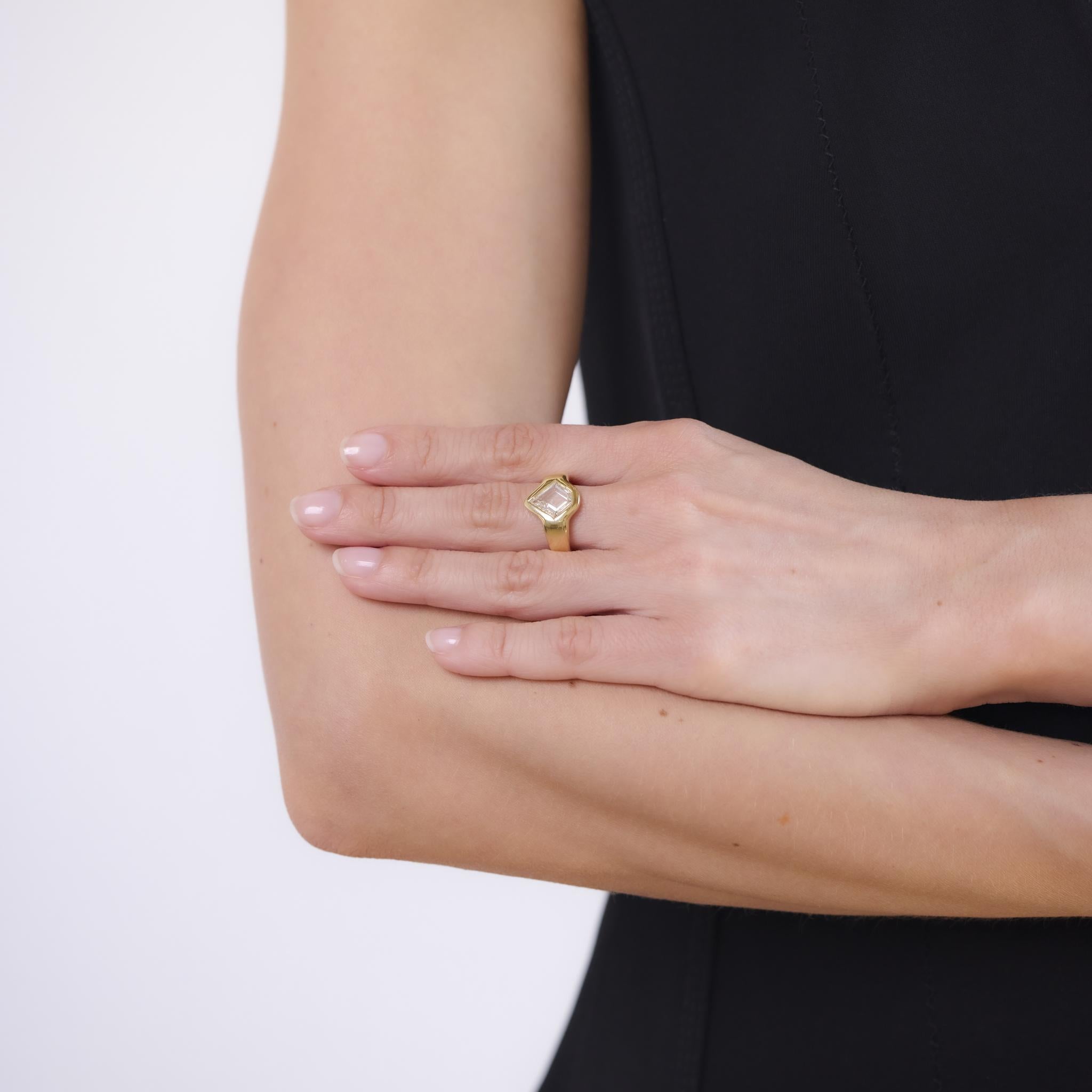 Questo moderno anello degli anni '20 è realizzato in oro giallo 18 carati e mette in mostra un sorprendente diamante taglio aquilone da 1,51 carati, certificato da GIA (#2507413150) con colore F e purezza VS2. La geometria unica della pietra