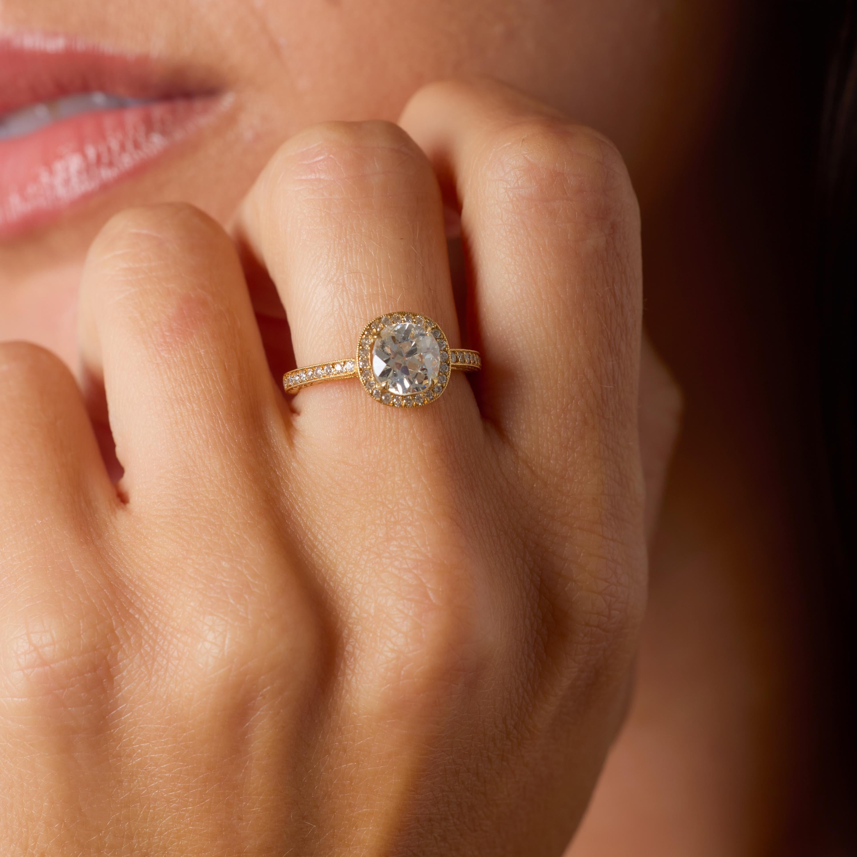 Este excepcional anillo de compromiso moderno combina el encanto conmovedor de los diamantes de talla antigua con la calidez del oro amarillo de 18 quilates, creando una pieza atemporal y expresiva a la vez. En su corazón descansa un diamante de