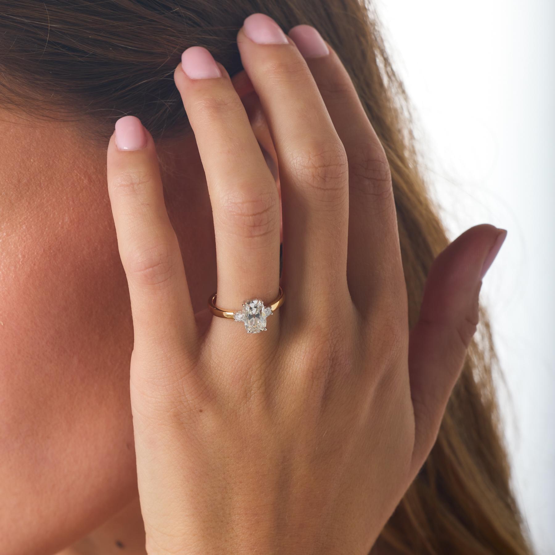 Chaleureuse et romantique, cette bague de fiançailles moderne met en valeur un diamant coussin brillant de 1,52 carat certifié par la GIA, dont le facettage influencé par les mines anciennes brille d'une douce profondeur et d'un charme antique. Sa