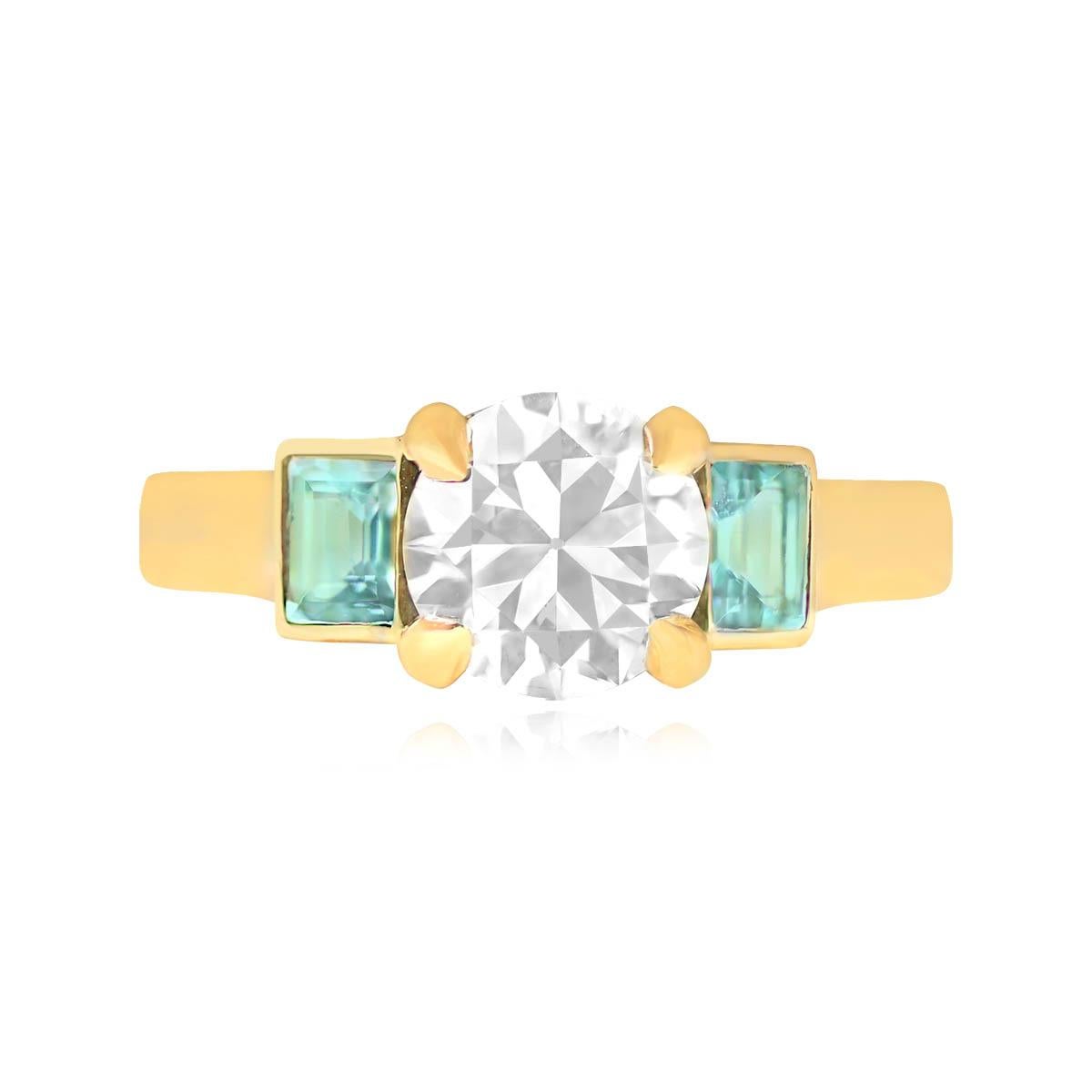 Striking ring highlighting a GIA-certified, prong-set 1.54-carat old European cut diamond at the center, boasting K color and VS2 clarity. The shoulders are adorned with two bezel-set baguette-cut aquamarines, adding a touch of elegance. Crafted