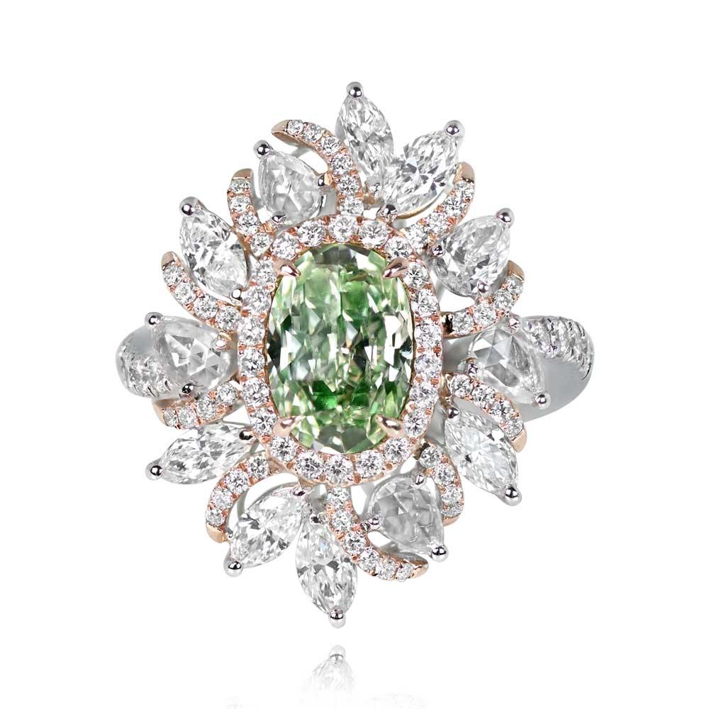 Cette bague de fiançailles de type halo présente en son centre un diamant ovale de 1,54 carat certifié par la GIA, de couleur fantaisie jaune-vert clair rare et de pureté VS1. Le diamant central est maintenu par des griffes et entouré d'un délicat