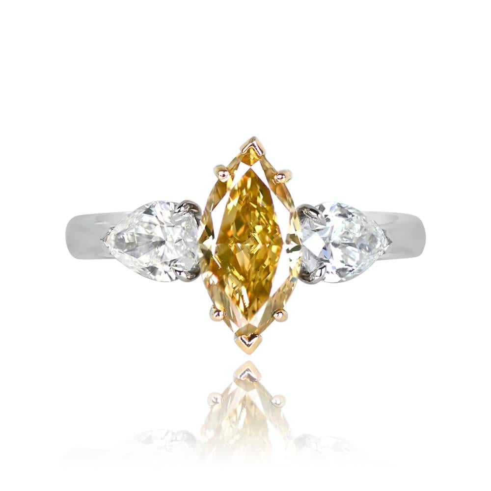 This three-stone ring highlights a GIA-certified 1.56-carat marquise-cut diamond in Fancy Deep Brownish Yellow. The central diamond is securely prong-set in yellow gold, flanked by two pear-shaped diamonds, each prong-set on a shoulder. The side