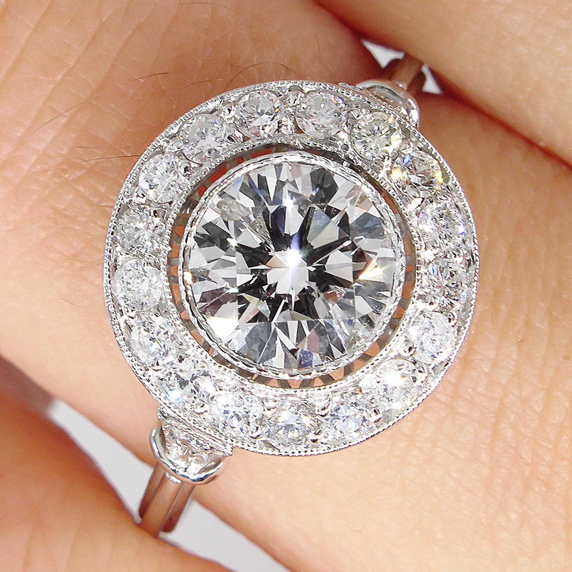 This breathtakingly beautiful Art Deco Inspired Vintage Diamond Halo Platinum Engagement Ring (tested), the Center Diamond is GIA certified 1.07ct Round Brilliant center diamond in K color and I2 clarity (Appears Whiter and eye clear); with