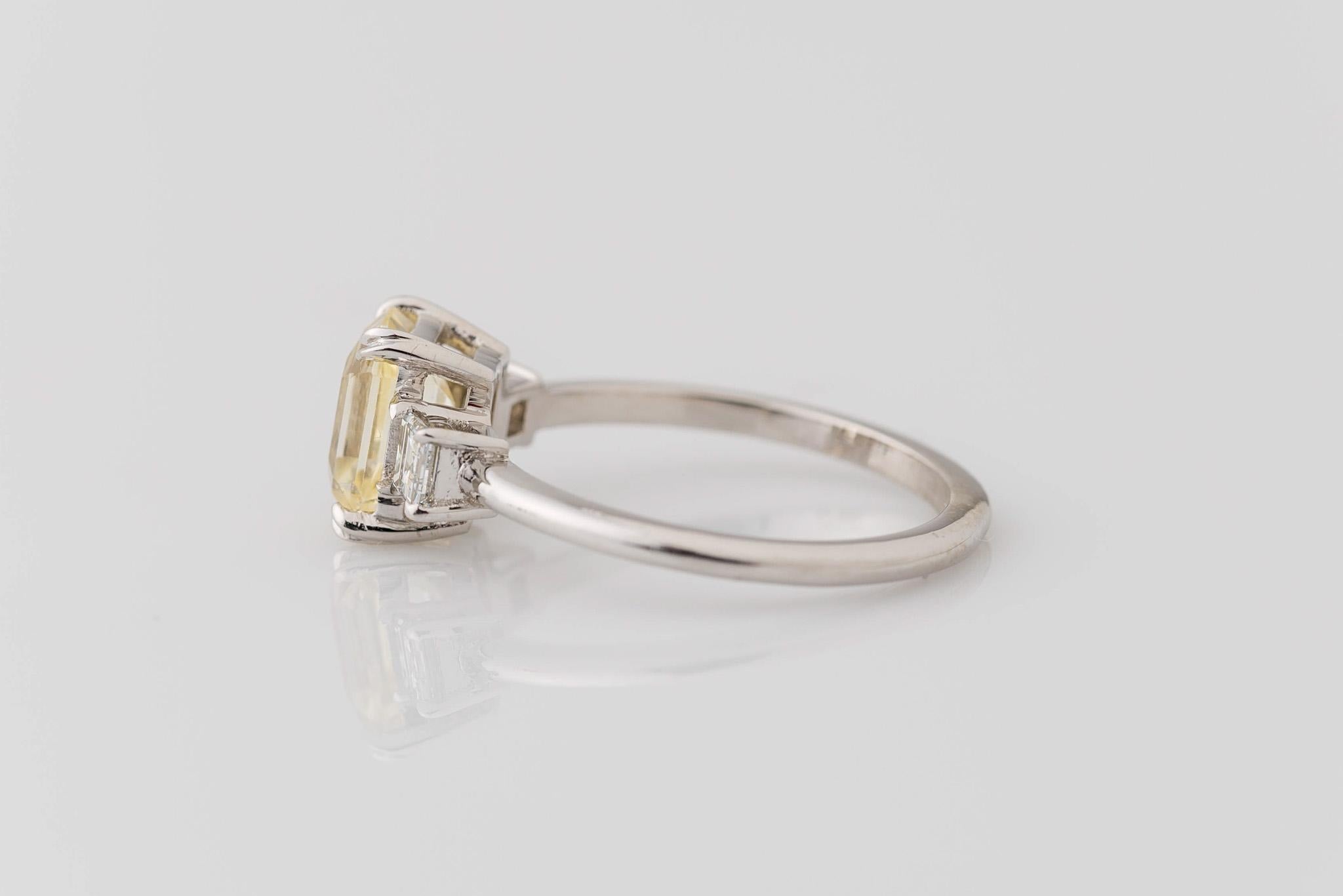Embrace eternal love with our enchanting 14K White Gold 3-Stone Wedding Ring. At its heart shines a GIA certified unheated transparent yellow sapphire, a symbol of unwavering commitment, weighing 1.63 carats and measuring 7.48x5.58x3.96mm in an