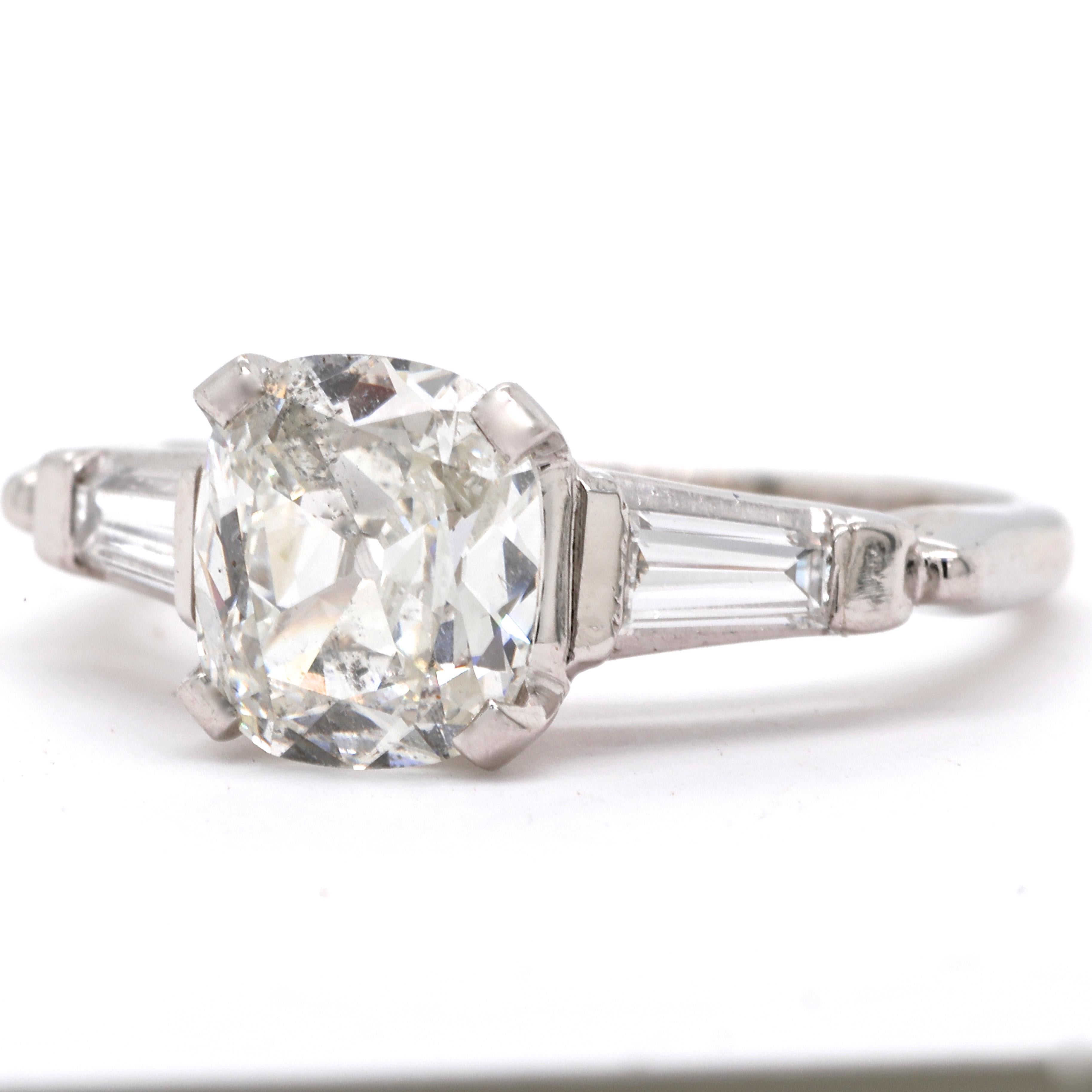 The perfect, elegant vintage engagement ring that you can wear every day. Celebrate love and beauty daily. The center diamond is GIA certified 1.67 carat, antique cushion cut, I color, I1 clarity (#2336975422). Accented by 2 tapered baguettes