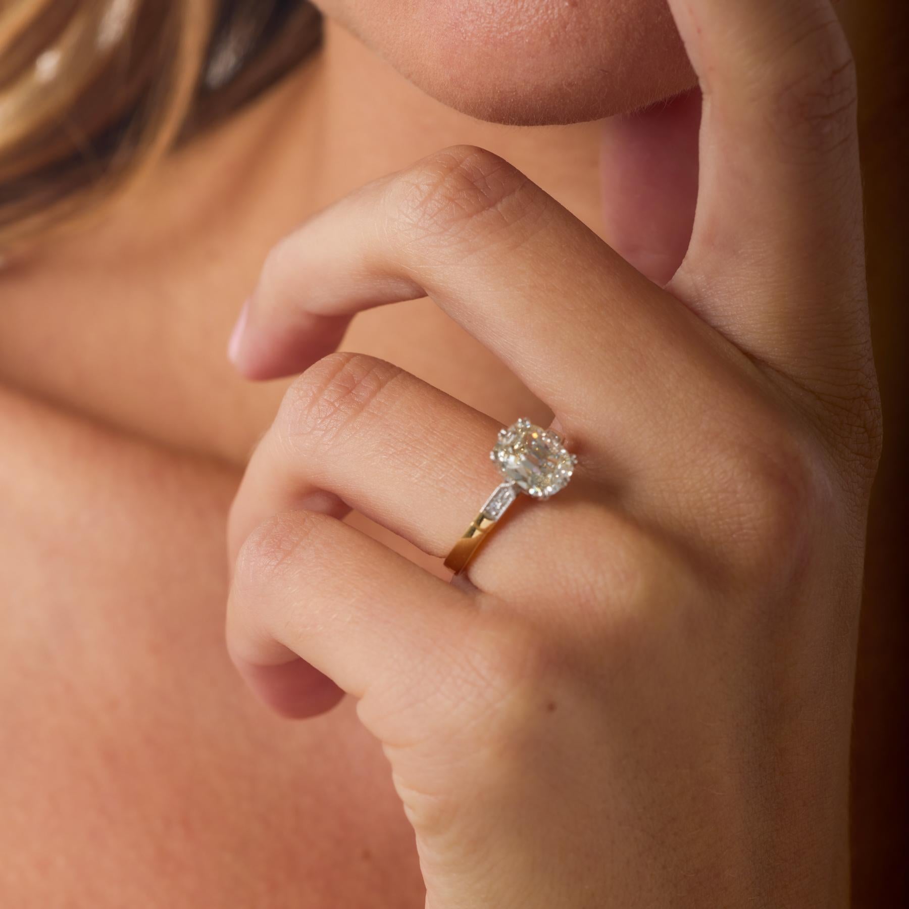 Rayonnant de chaleur et d'une clarté exceptionnelle, cette bague de fiançailles moderne met en valeur un diamant coussin brillant de 1,67 carat certifié par la GIA, dont l'influence des anciennes mines est visible dans ses facettes romantiques et