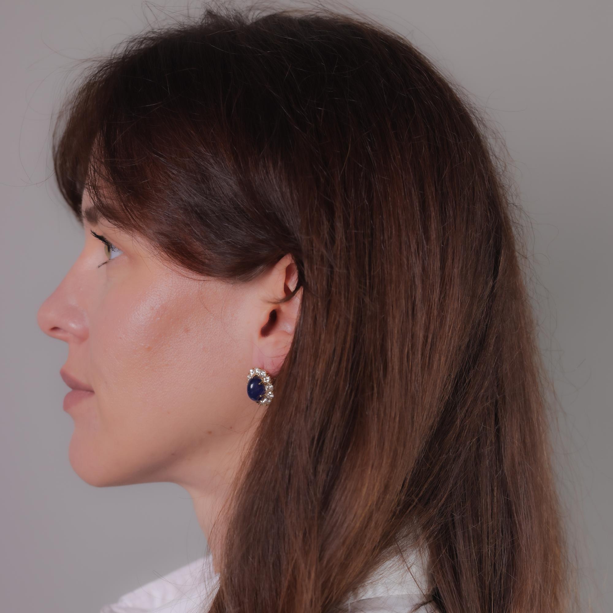 Cette paire de boucles d'oreilles vintage en or jaune et blanc 18k présente deux saphirs bleus ovales à double cabochon certifiés GIA provenant du Sri Lanka, pesant 7,75 et 8,97 carats, chauffés, accentués par 24 diamants ronds de taille brillant et