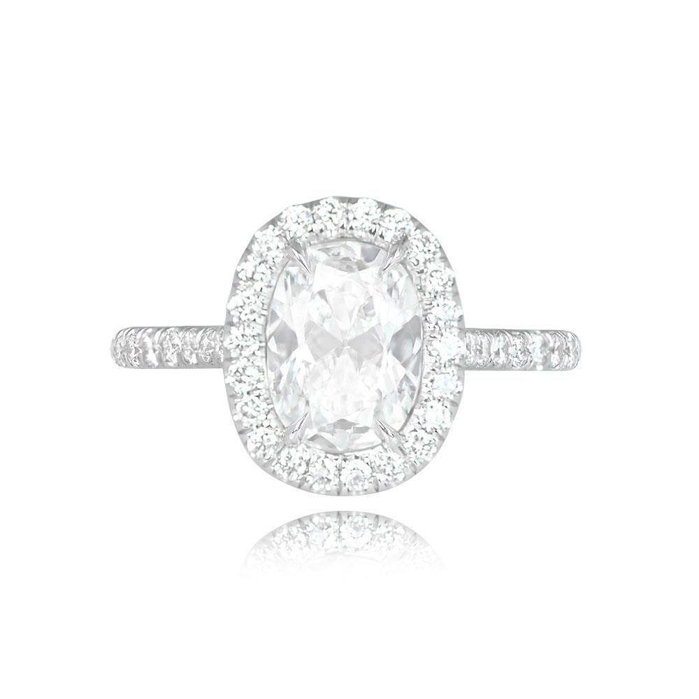 A GIA-certified 1.69-carat cushion-cut diamond in F color and SI1 clarity is elegantly set in prongs. The center stone is encircled by a micropave halo of round brilliant-cut diamonds. Round brilliant cut diamonds are also set on the shoulders of