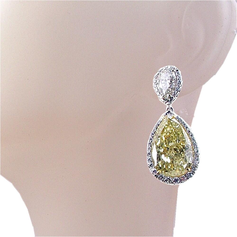 This 18K  beautiful dangling earring features 2 GIA certified Fancy Yellow Pear Shape diamonds with total weight of 18.18 Ct (9.07 Ct & 9.11 Ct) Hanging off of a pair of Pear Shape diamonds with total weight of 2.01 Ct. (GIA 0.99 Ct G/SI2 & EGL 1.02