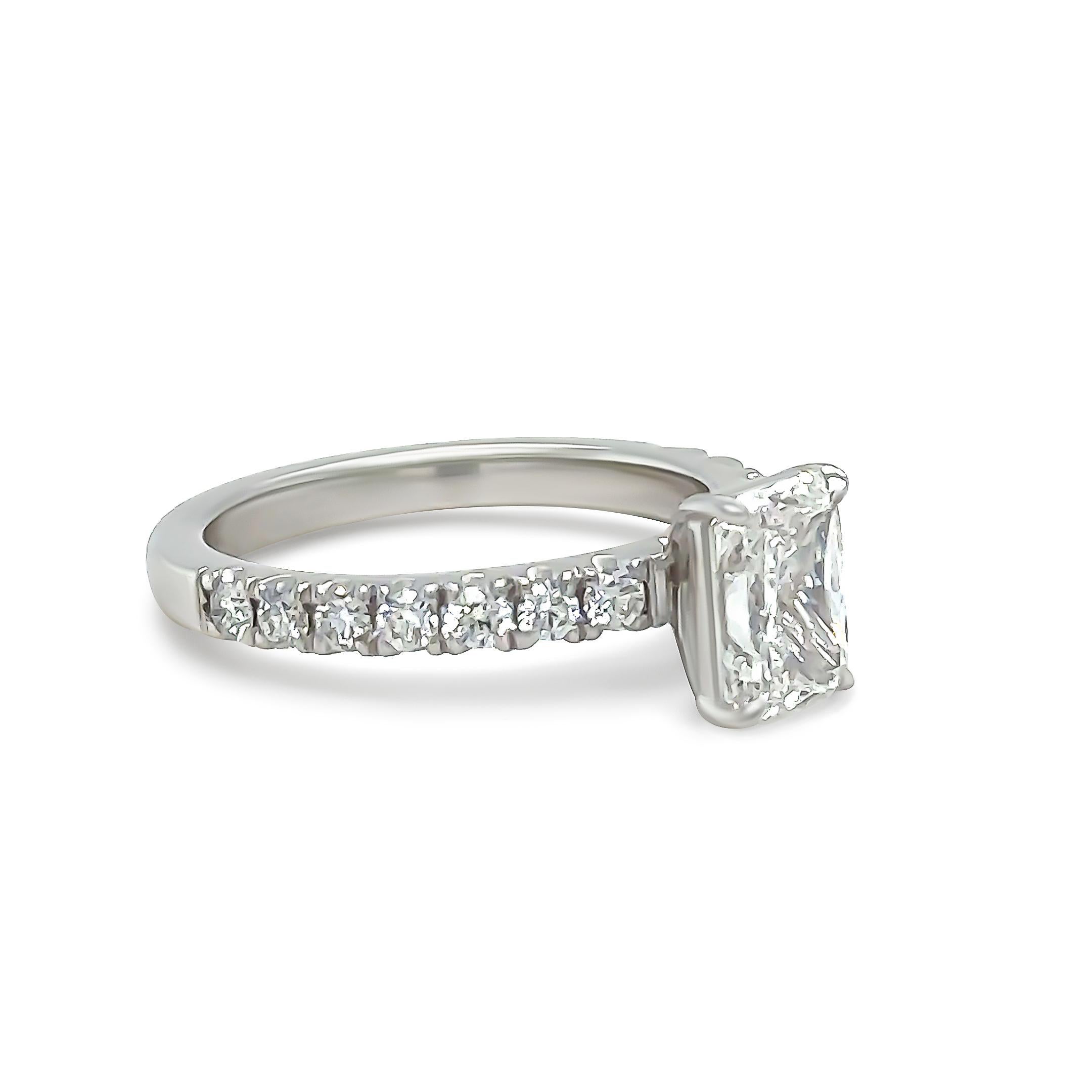 A GIA Diamond Engagement Ring, made of 18ct White Gold. Featuring a Single Radiant Cut in a four claw setting with 7 Round Brilliant Cut Diamonds on each shoulder. 

GIA Diamond = 1 x Radiant Cut, F Colour, VS1 Clarity, total carat weight of
