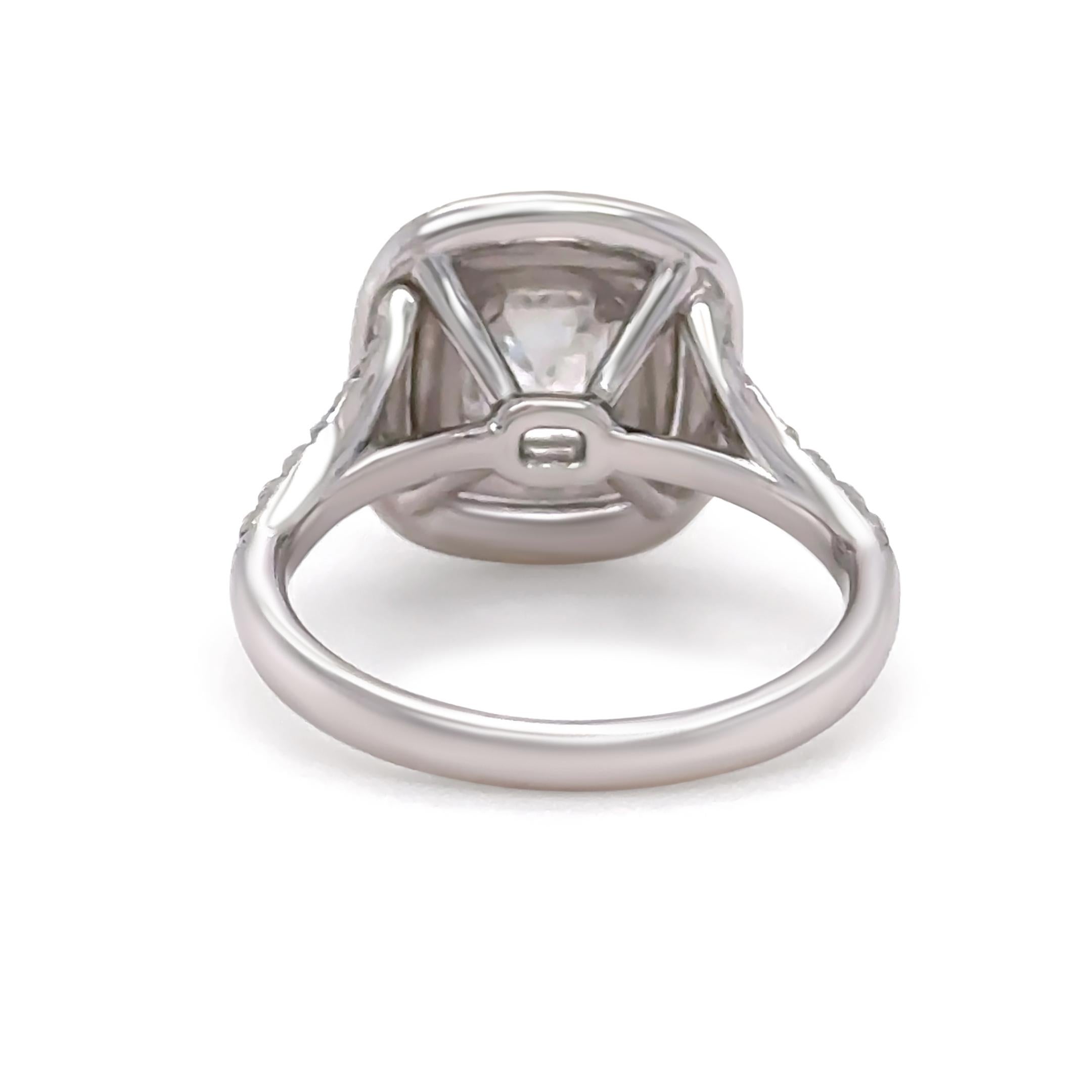 This exceptional GIA certified emerald cut diamond cluster ring is masterfully crafted in 18ct white gold, showcasing a breathtaking 1.50ct emerald cut diamond, four-claw set and framed by a double halo of 42 round brilliant-cut diamonds. The
