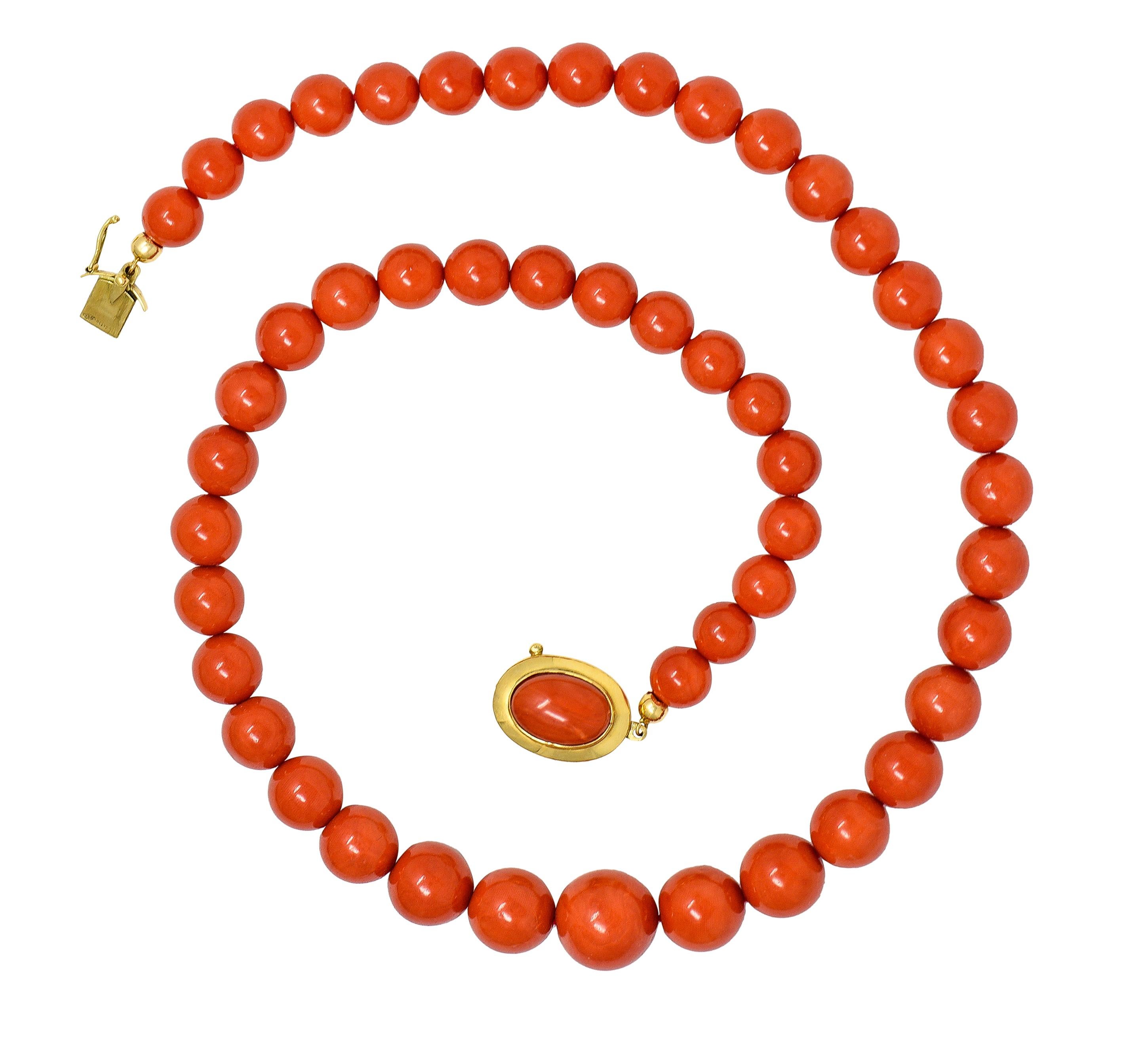 Bestehend aus abgestuften runden Korallenperlen mit einer Größe von 11,0 bis 18,0 mm. Transluzentes Rot-Orange ohne Hinweise auf eine Farbbehandlung. Abgerundet durch runde Goldklemmen mit ovalem Goldverschluss. Zentrierte ovale Korallencabochons