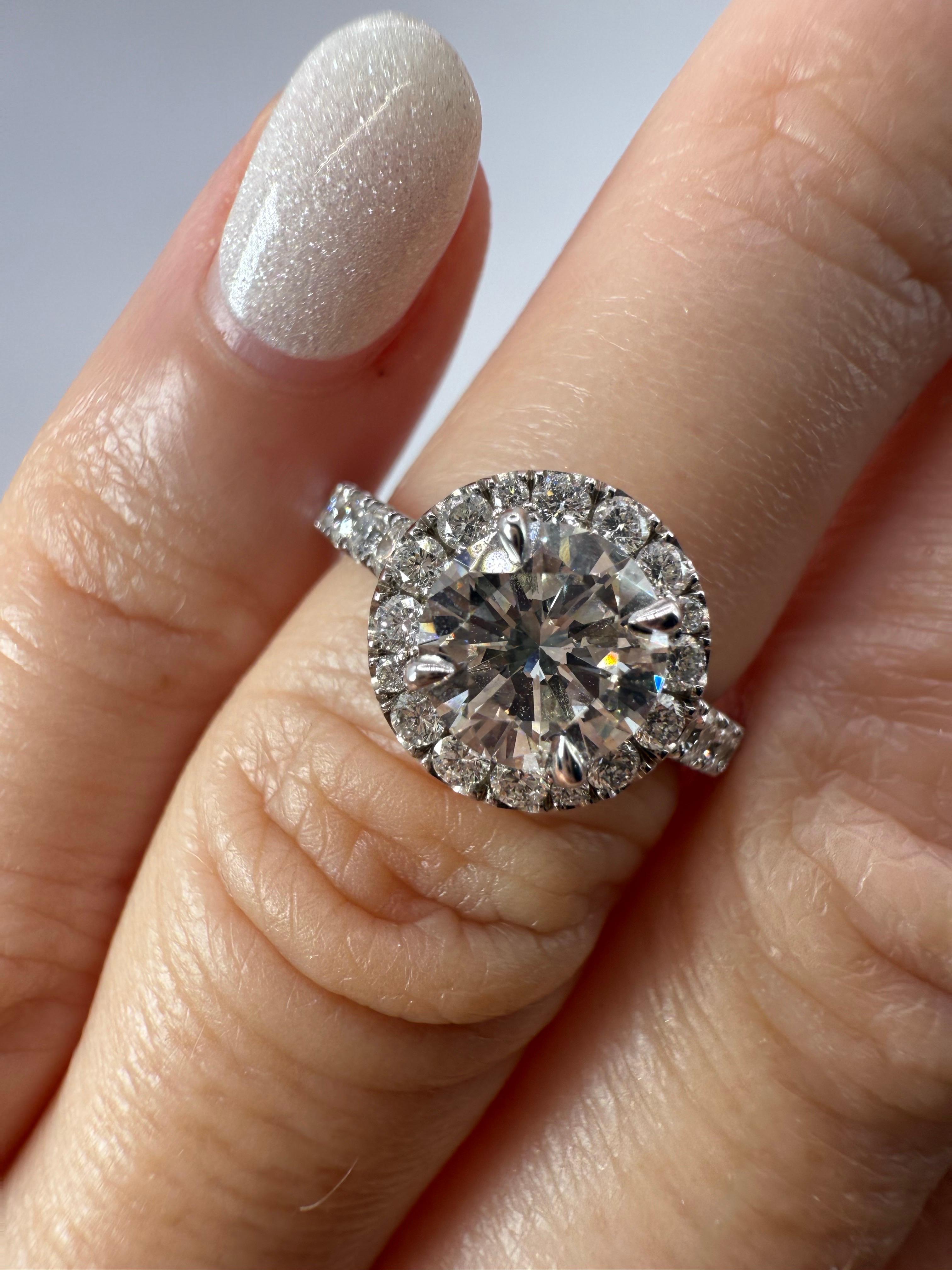 Anello di fidanzamento aureolato con 1 carato al centro e 0,88 carati di piccoli diamanti. Il diamante centrale ha una purezza VS2 e un colore H, mentre i diamanti piccoli hanno una purezza VS-SI e un colore G-H. L'anello misura 5,5 e può essere